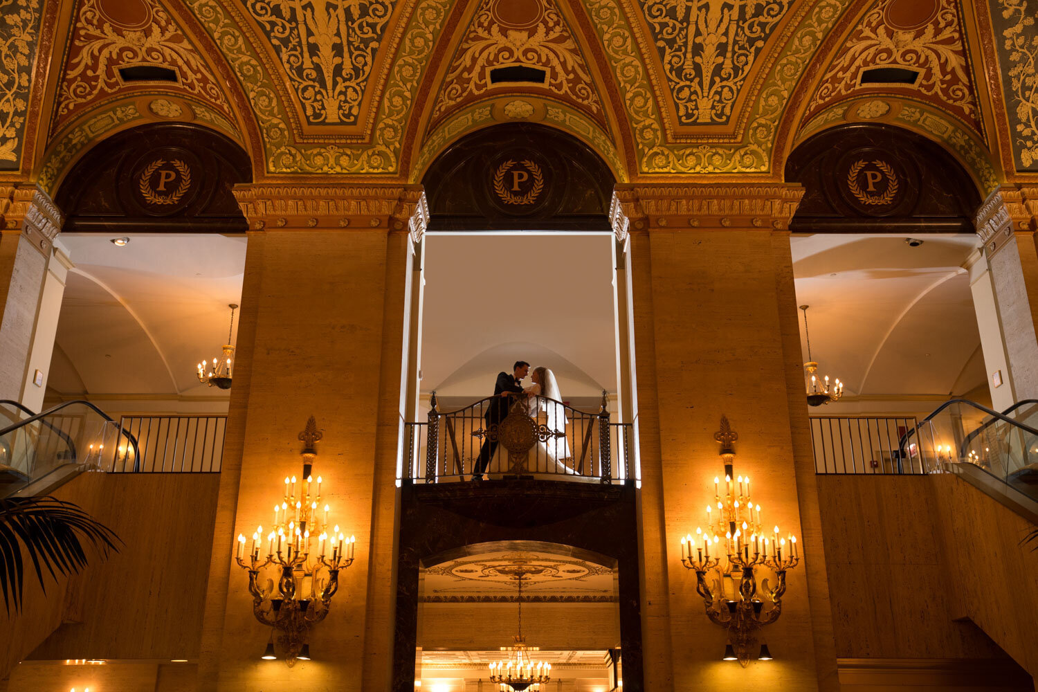 A bride and groom are dancing on a balcony in a building