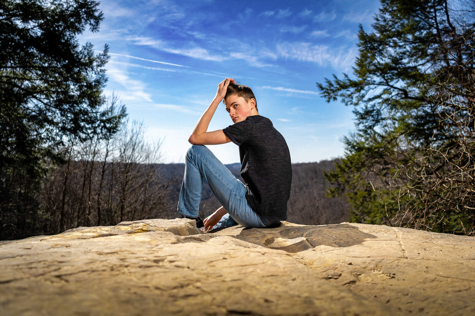 Pennsylvania senior photo of a senior sitting on the edge of an outlook, captured in a Pennsylvania State Park