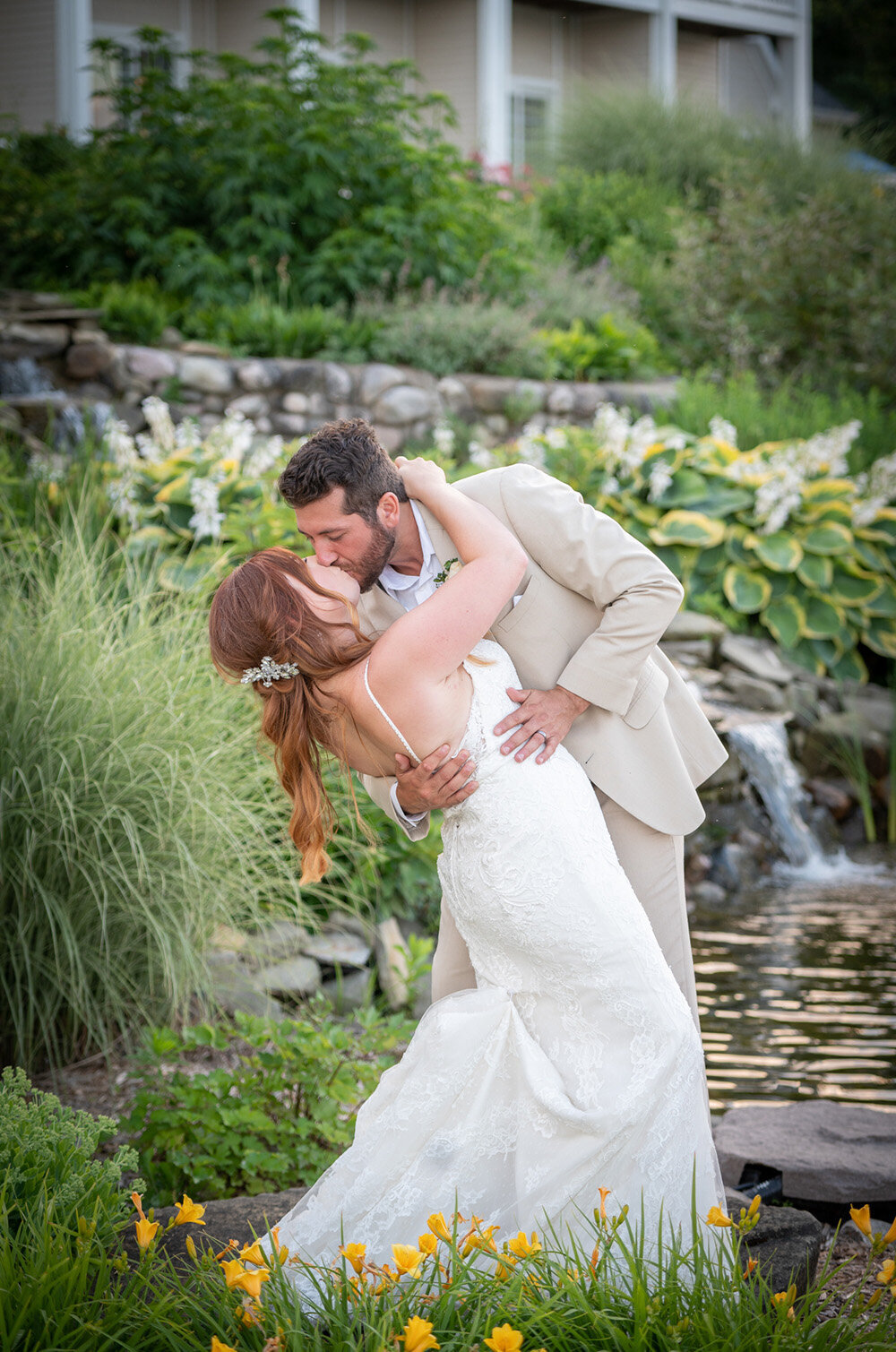 wedding couple dip and kiss in front of pond