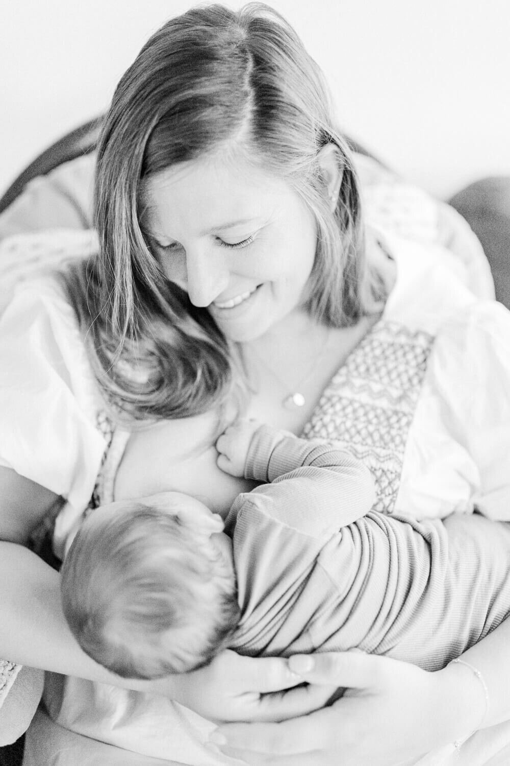 Mom smiling down at her baby while she nurses