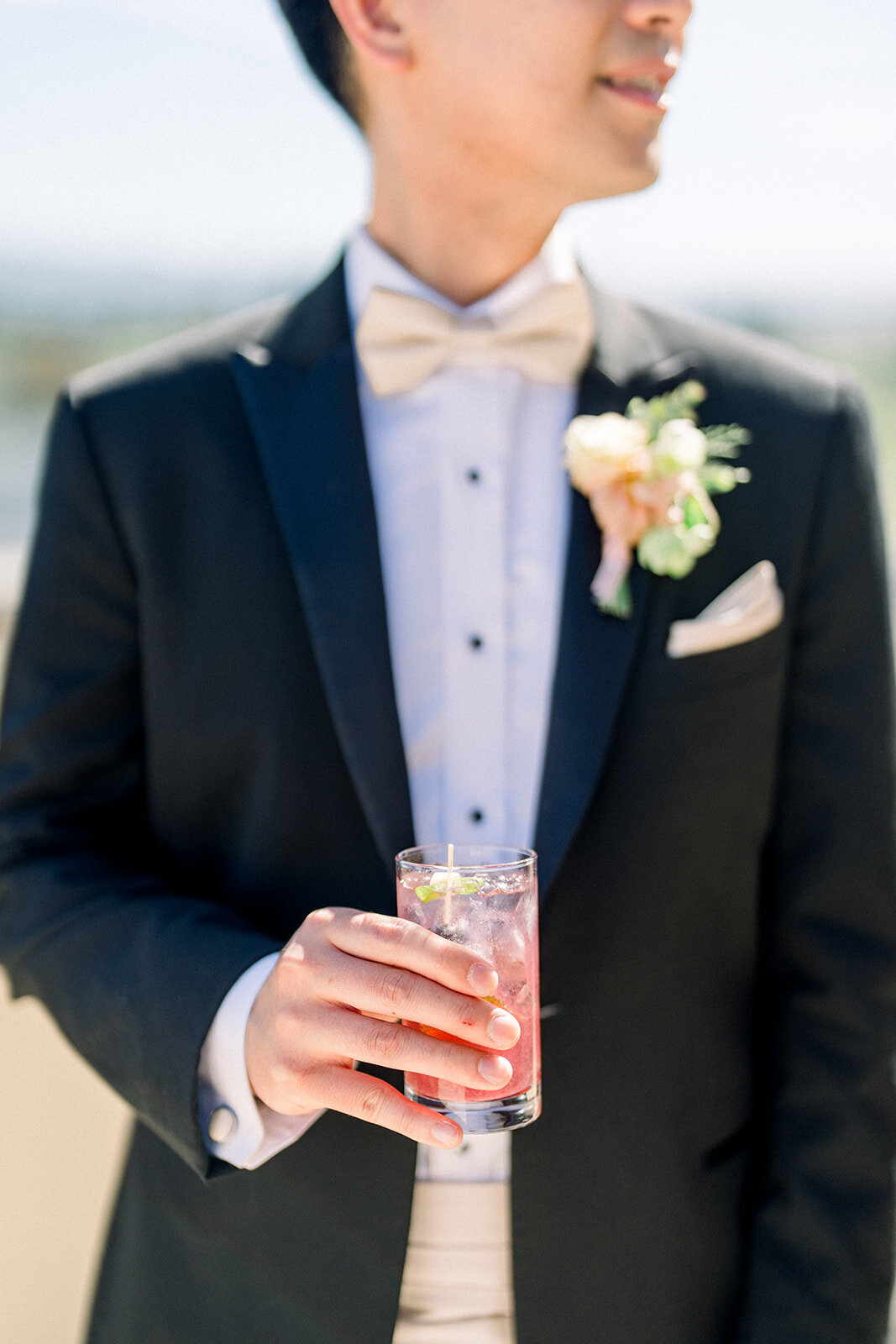 The groom elegantly displays the wedding invitation at Filoli, showcasing the luxurious reception in Woodside, California.