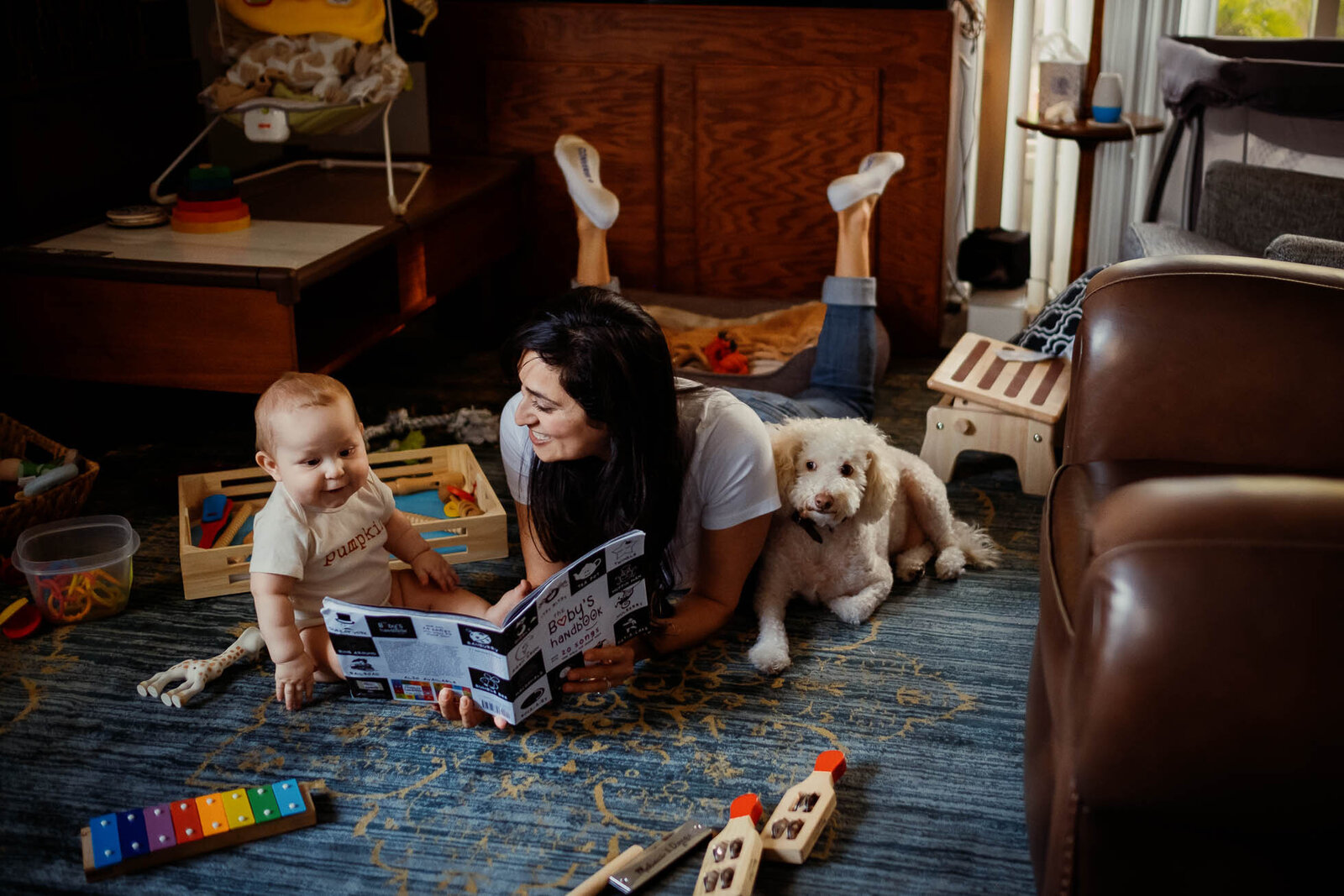 mom reads book for baby and dog
