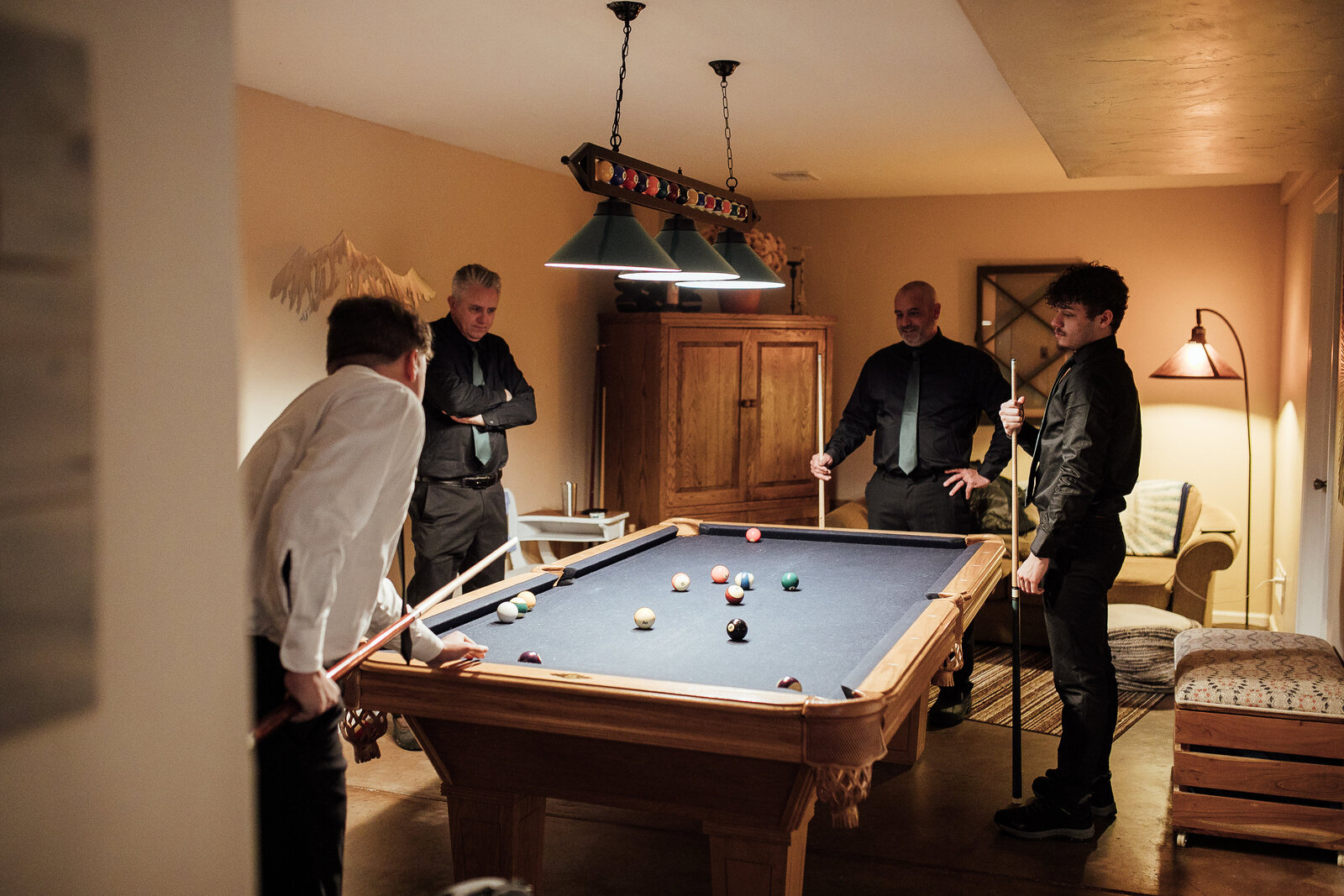 Groomsmen play pool before wedding ceremony