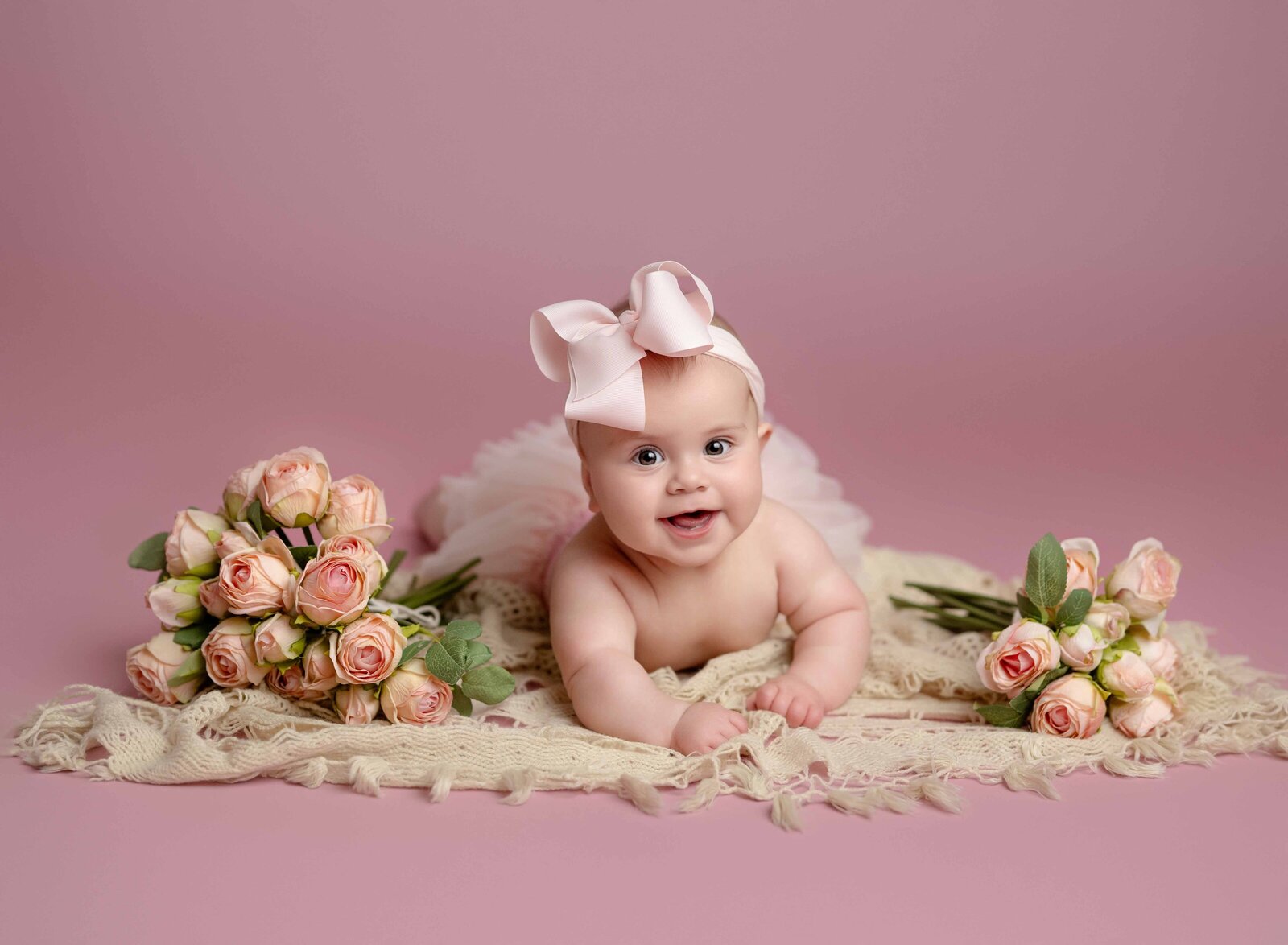 Baby girl in pink tutu, laying on belly smiling with poses on each side.