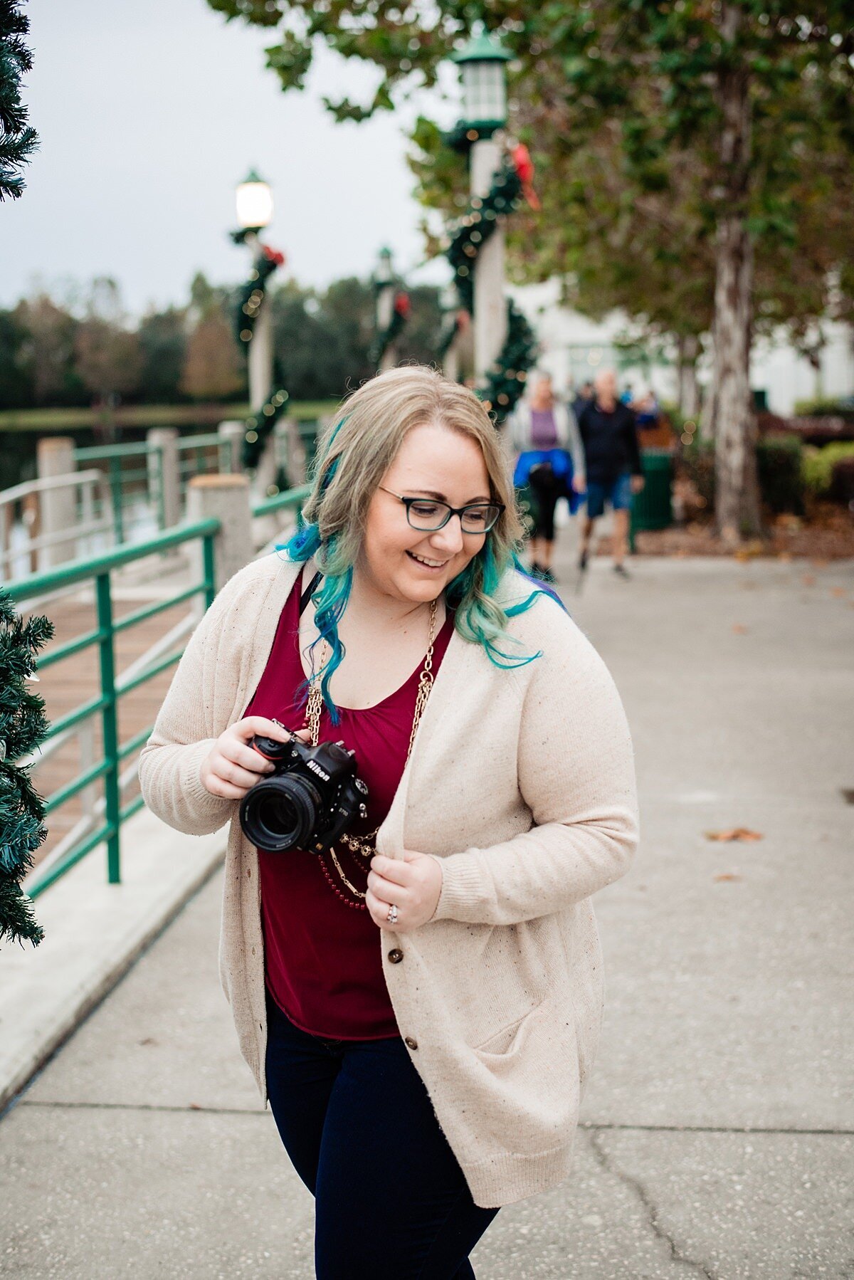 Mahlia holding a Nikon camera outside at Christmas time