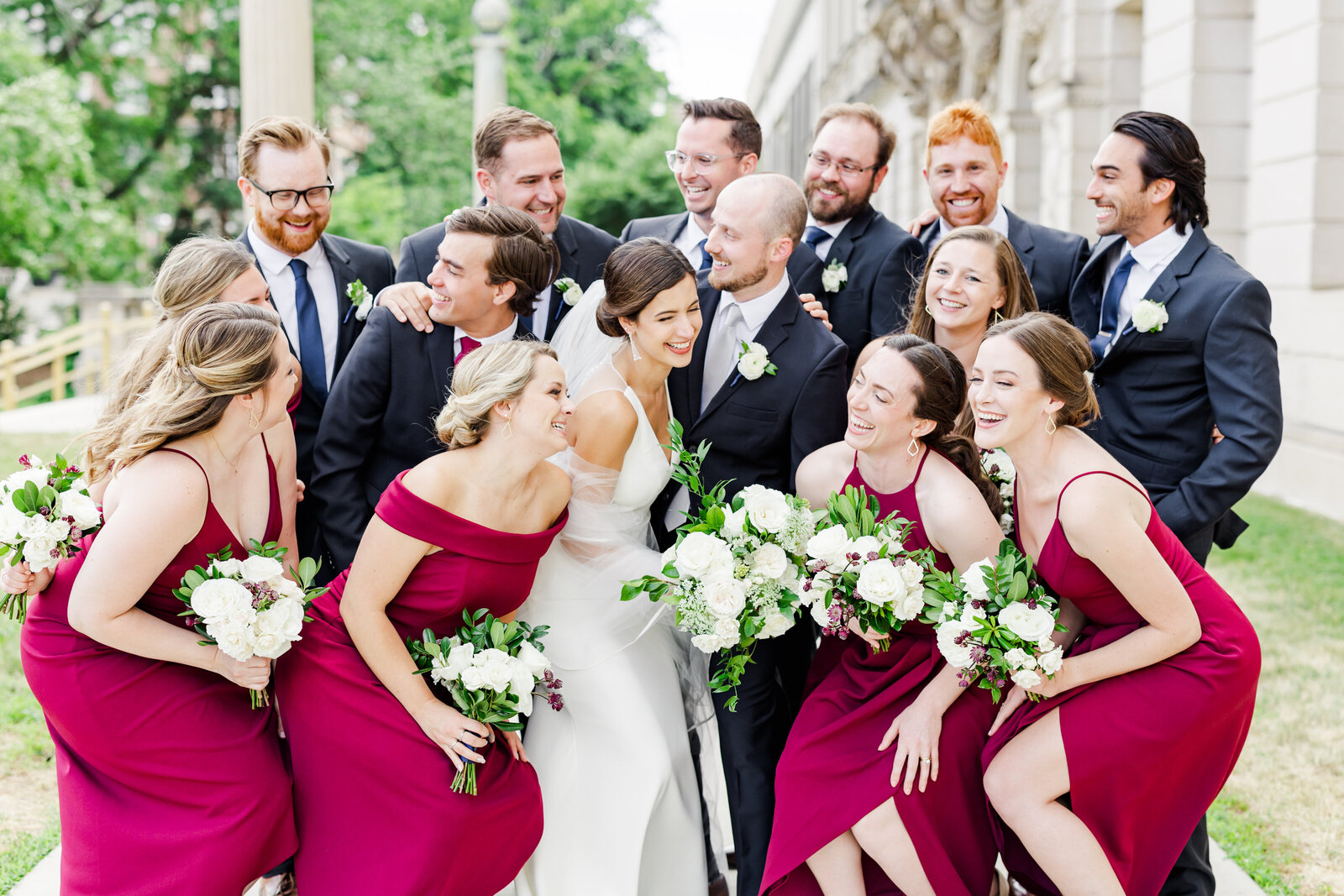 19_wedding_party_in_red_blue_laughing_closely_together_madison_historical_building