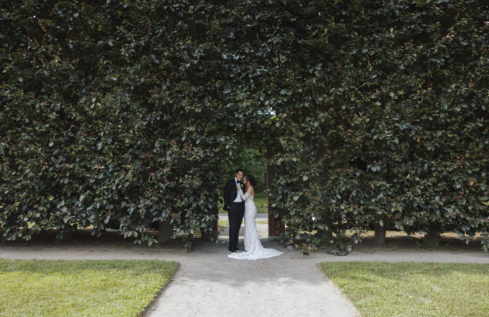 A Bride and Groom Stand in an Archway Through The Hedge at The Garden at Elm Bank in Wellesley, Massachusetts 