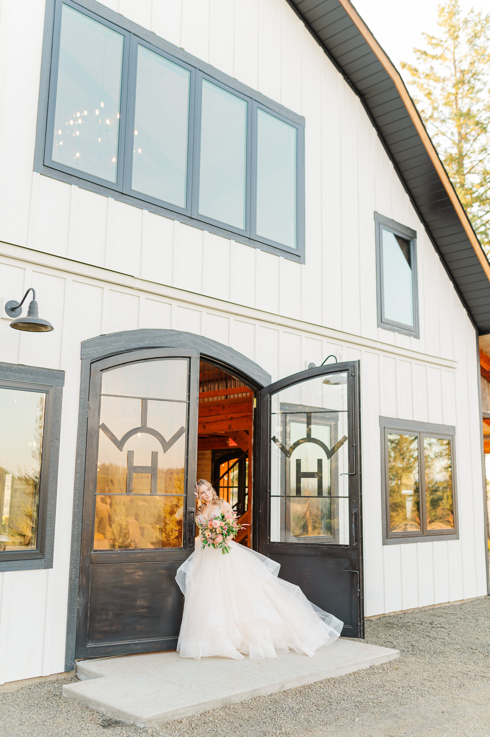 bride in doorway at white barn wedding venue in deary idaho called edge of heaven weddings and events