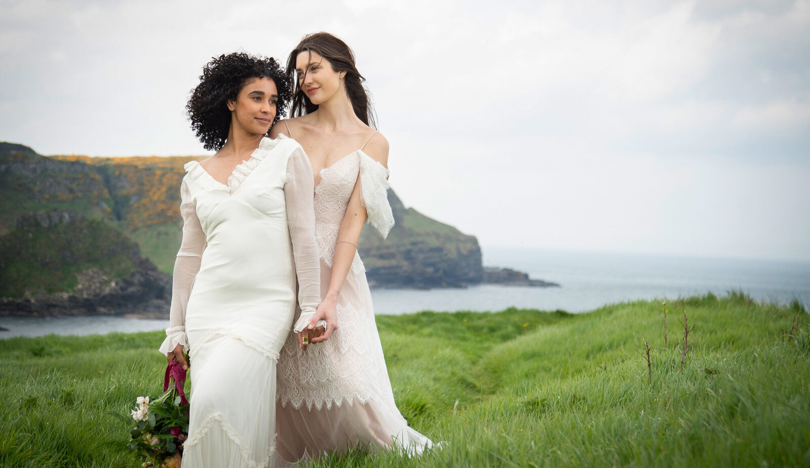 brides stand together on bluff