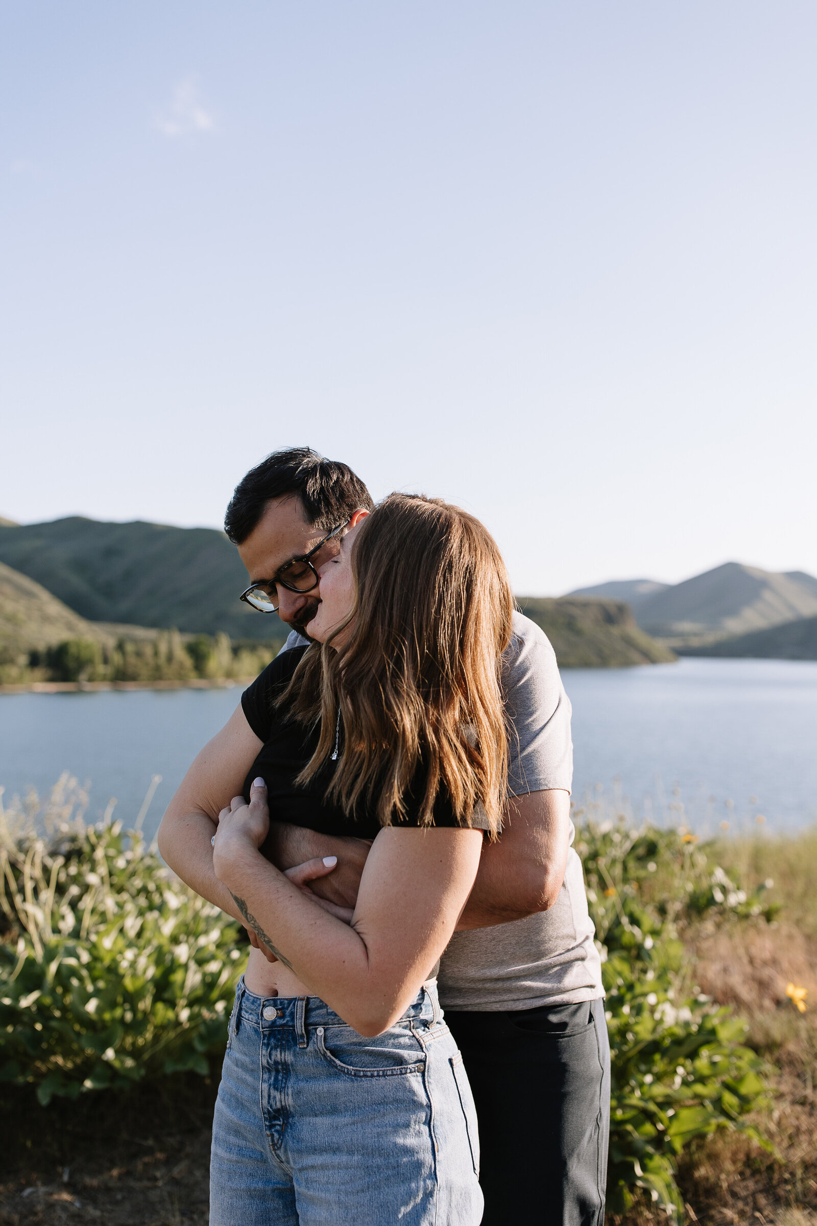 Playful couple embracing during golden hour engagement session in Boise, Idaho