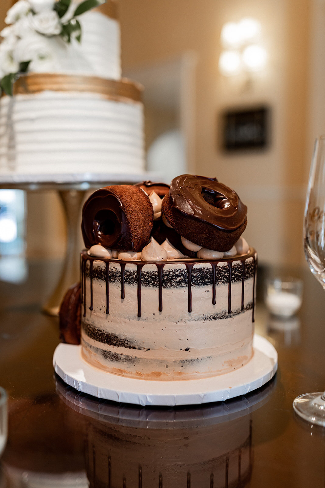 chocolate wedding cake with dripped icing and chocolate donuts on top