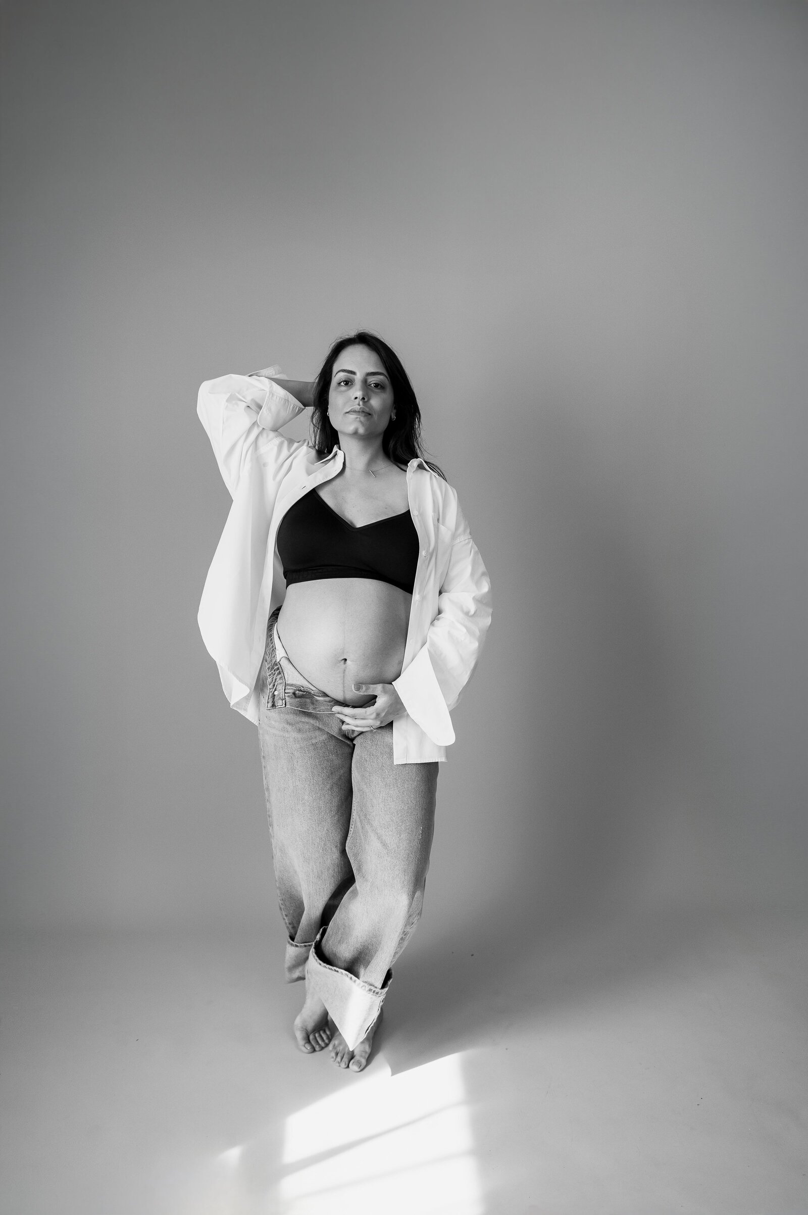pregnant mom in jeans and white shirt for photoshoot