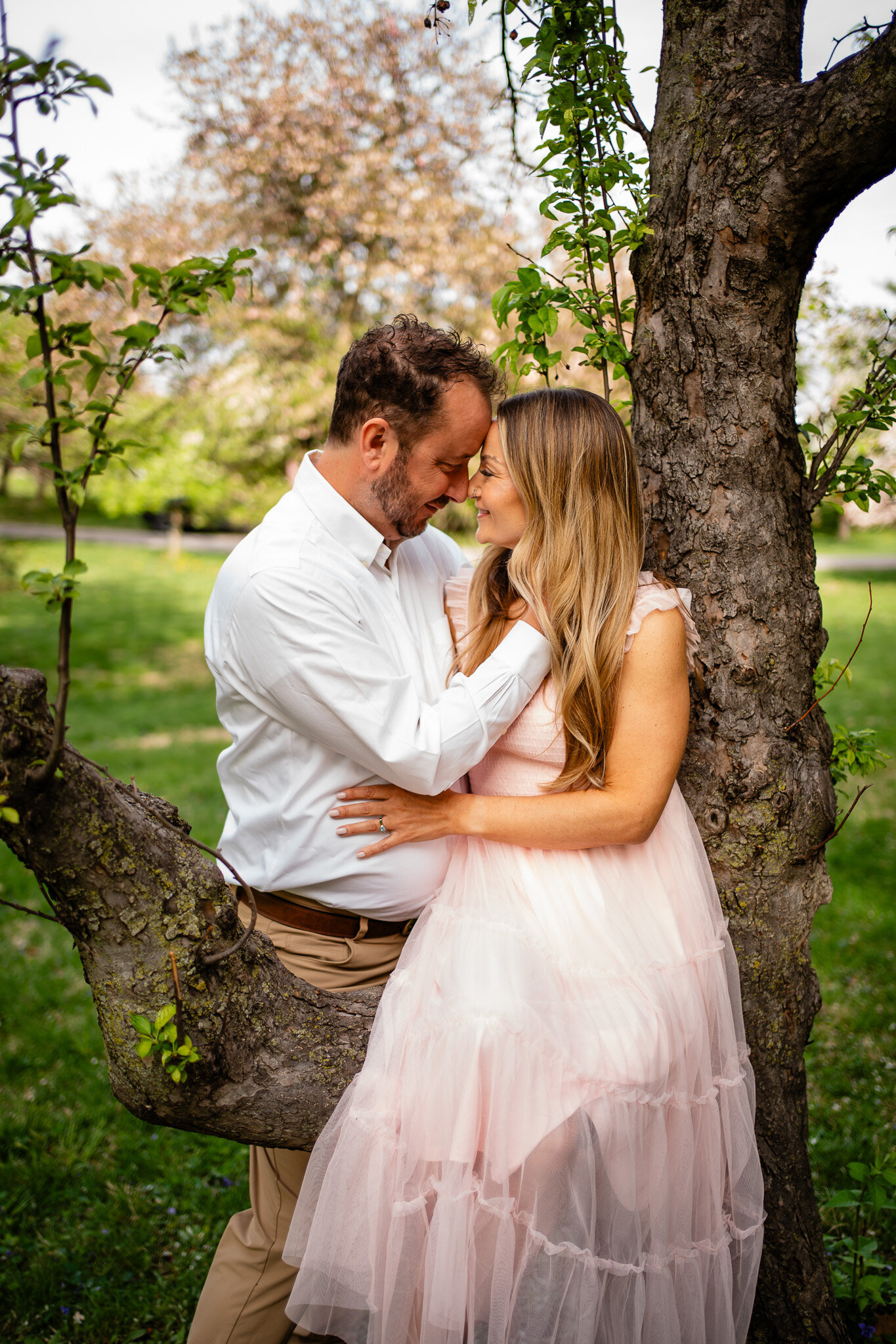 engagement photos couples photos at waterworks park in the crap apples trees cherry blossom trees Des Moines Iowa
