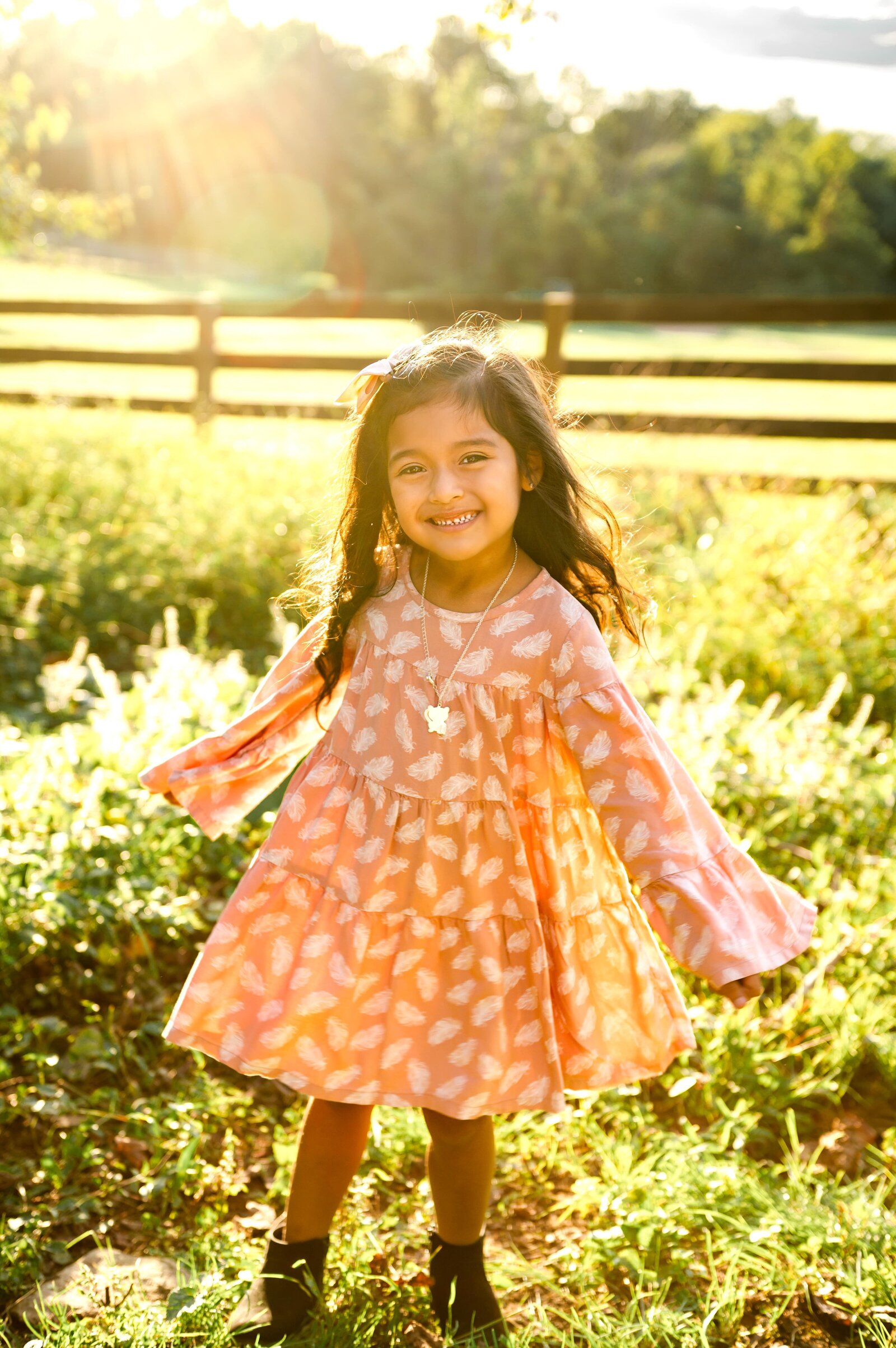 girl twirling in a field in Monkton, Maryland with a pink dress
