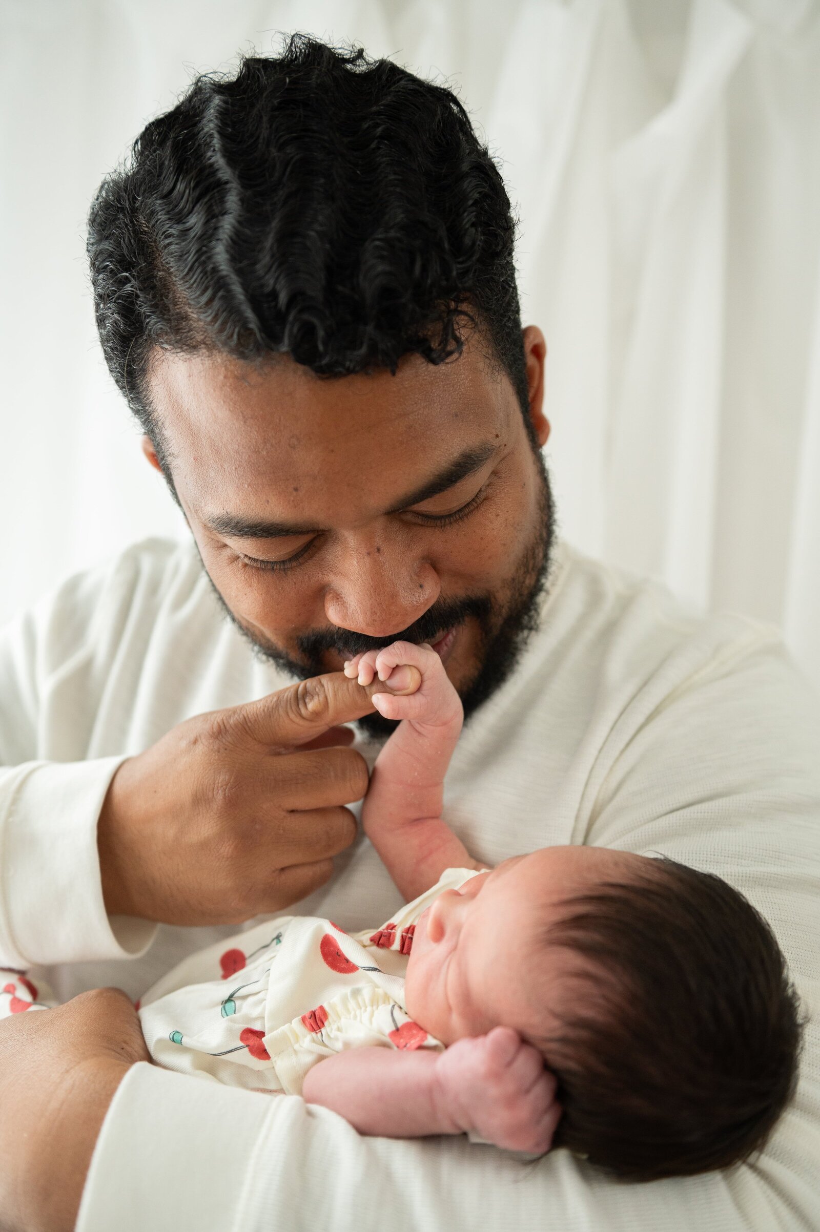 Candid moment between dad and baby during a relaxed Baltimore newborn photo session at home.

