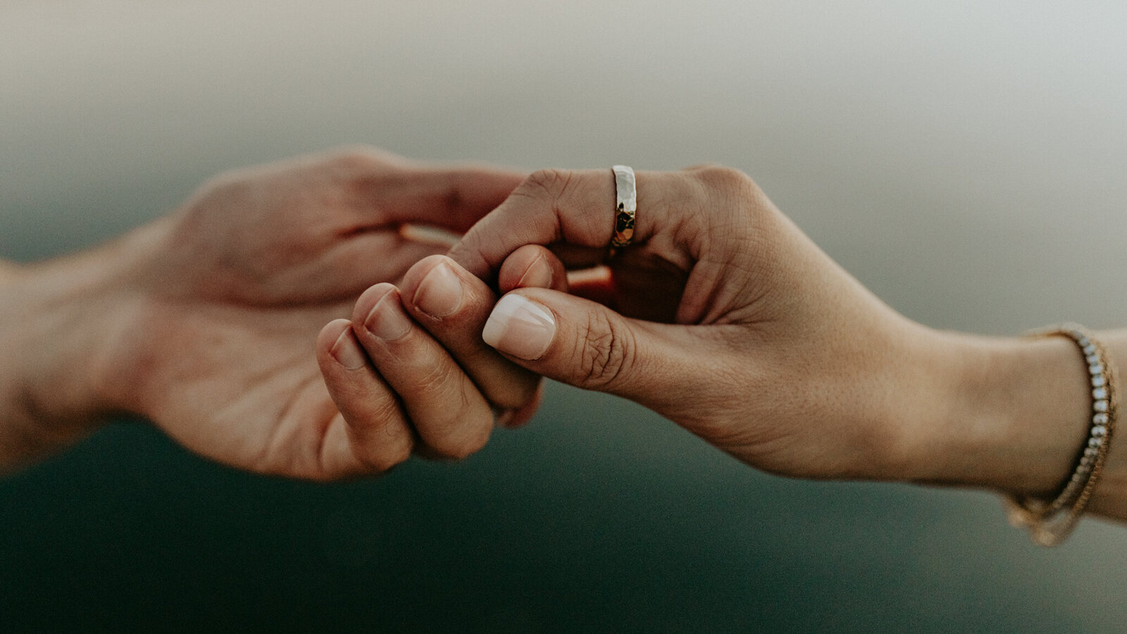 Married couple running while bride holding her gown and her husband's hand