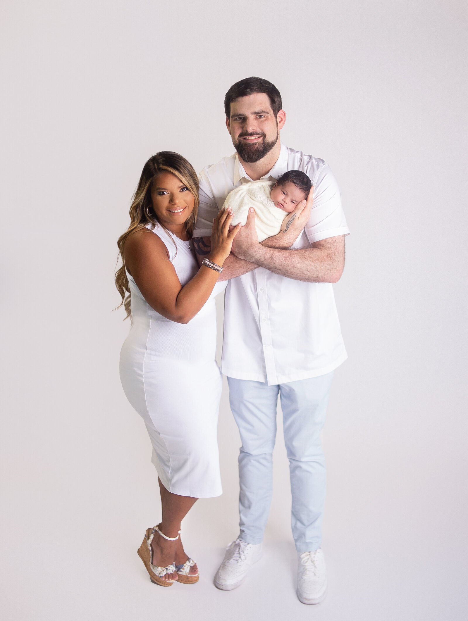 Mom and dad holding newborn baby during newborn photoshoot with Nashville, Tennessee newborn photographer