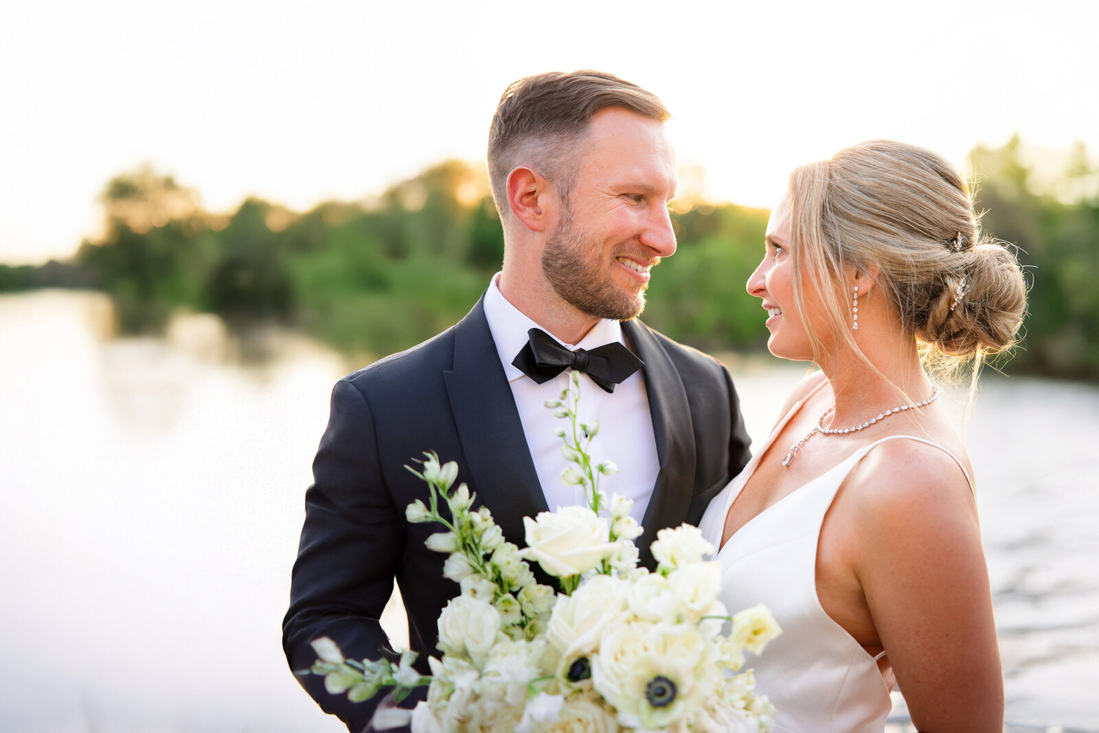 Bride and groom near the river in old sacramento at sunset looking into each others eyes captured by sacramento wedding photography Ashley Teasley