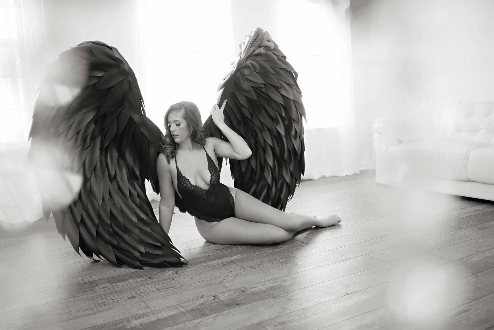 Woman posing in large black boudoir wings