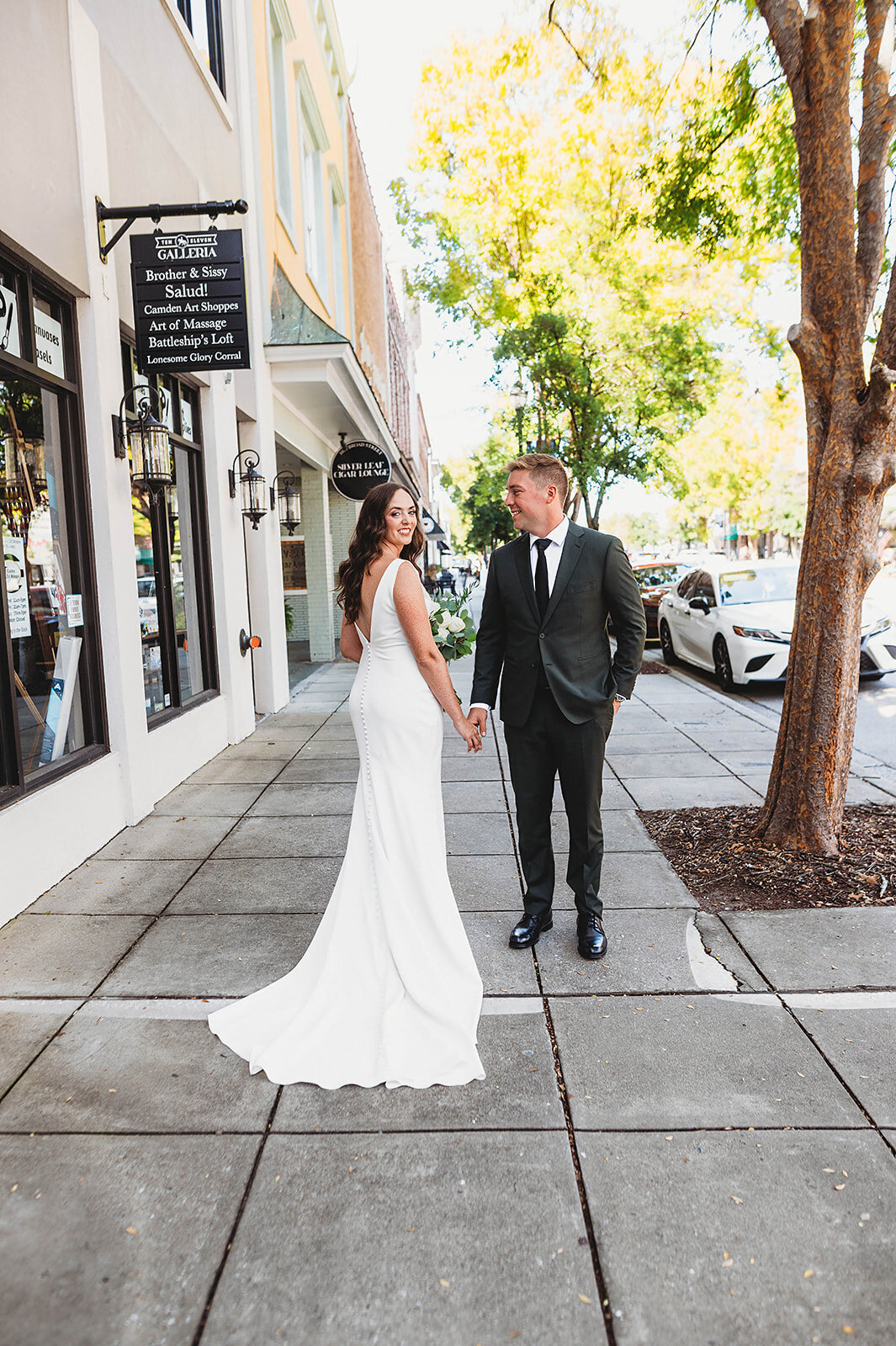 bride and groom pose downtown in SC for their photos before wedding