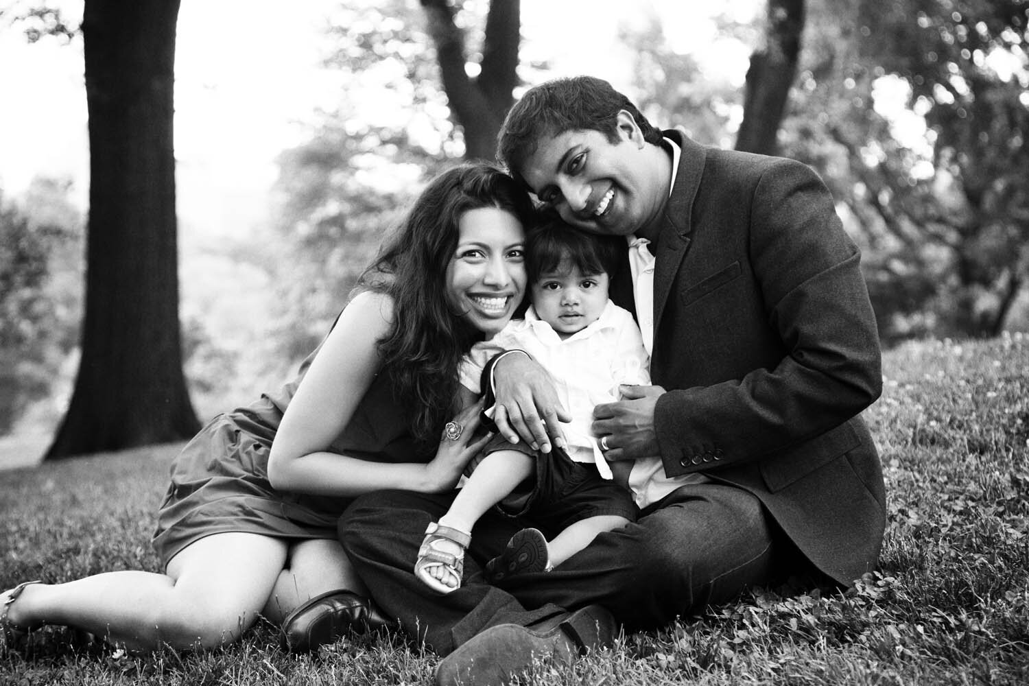 A family pose for a portrait on a grassy lawn in Central park, New York City