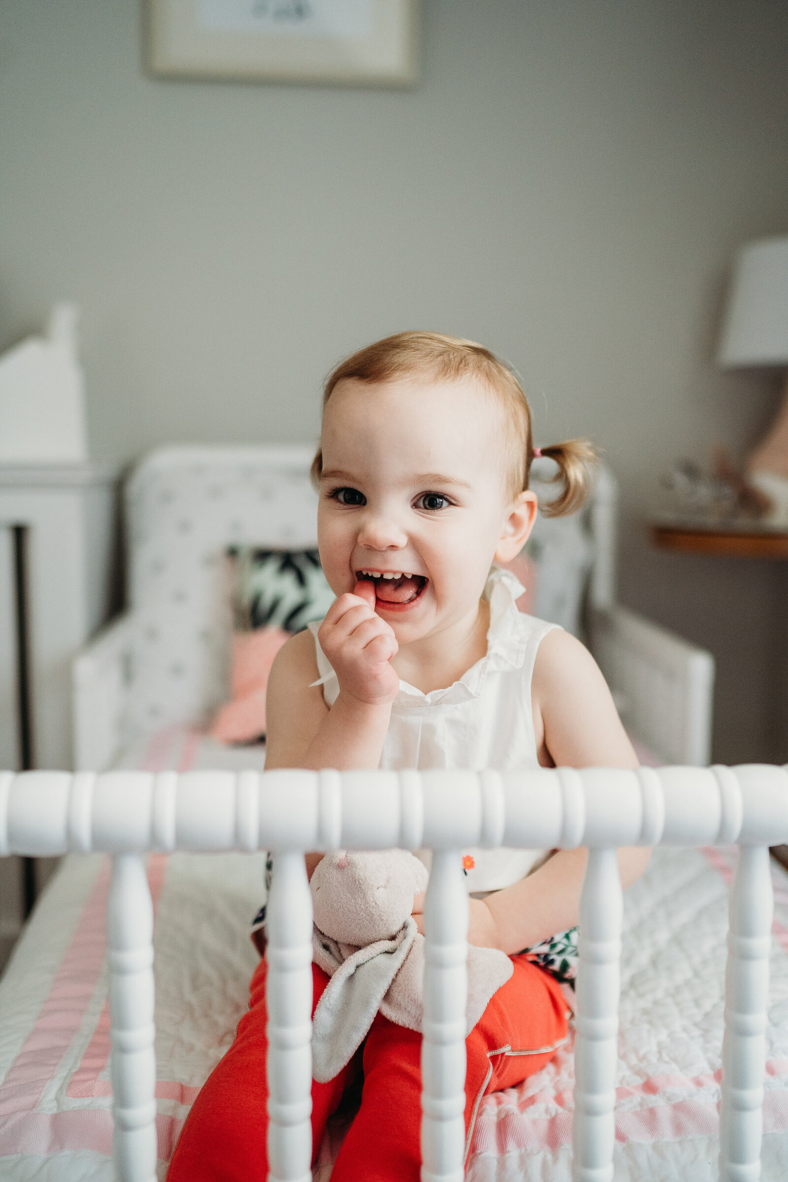 girl laughs on white bed