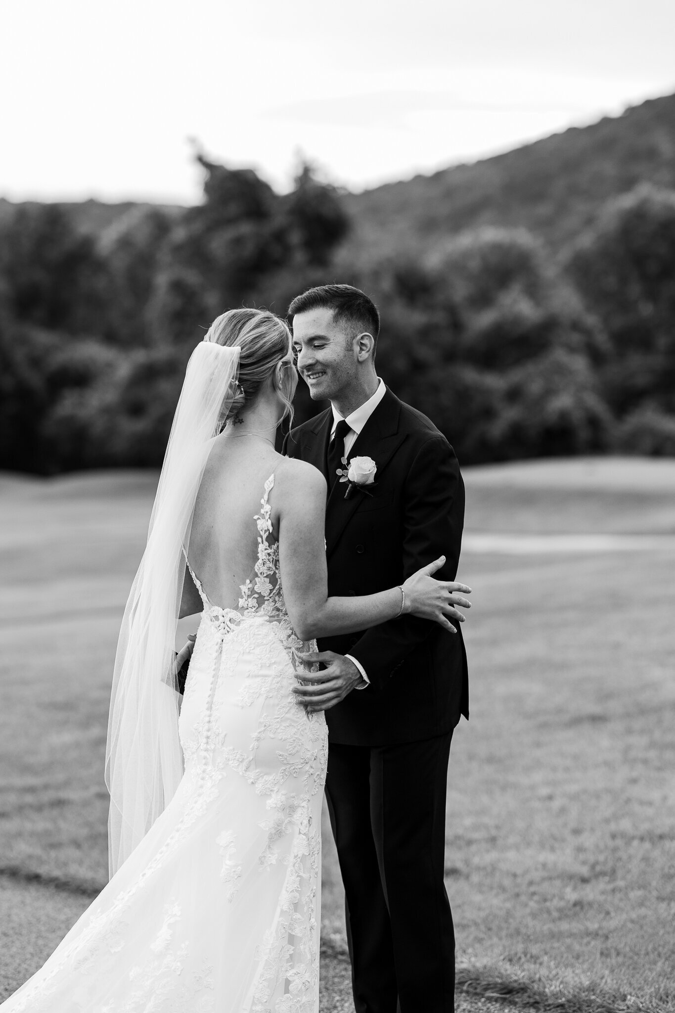 Black and white photo of bride and groom kissing during first look at SkyView Golf Club