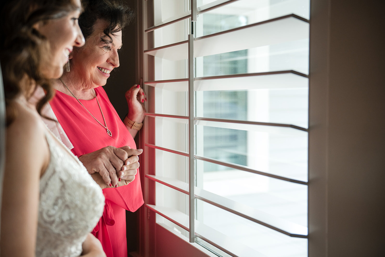 A serene moment of the bride gazing out the window as she prepares for her wedding day, captured by CMH Studios in San Antonio