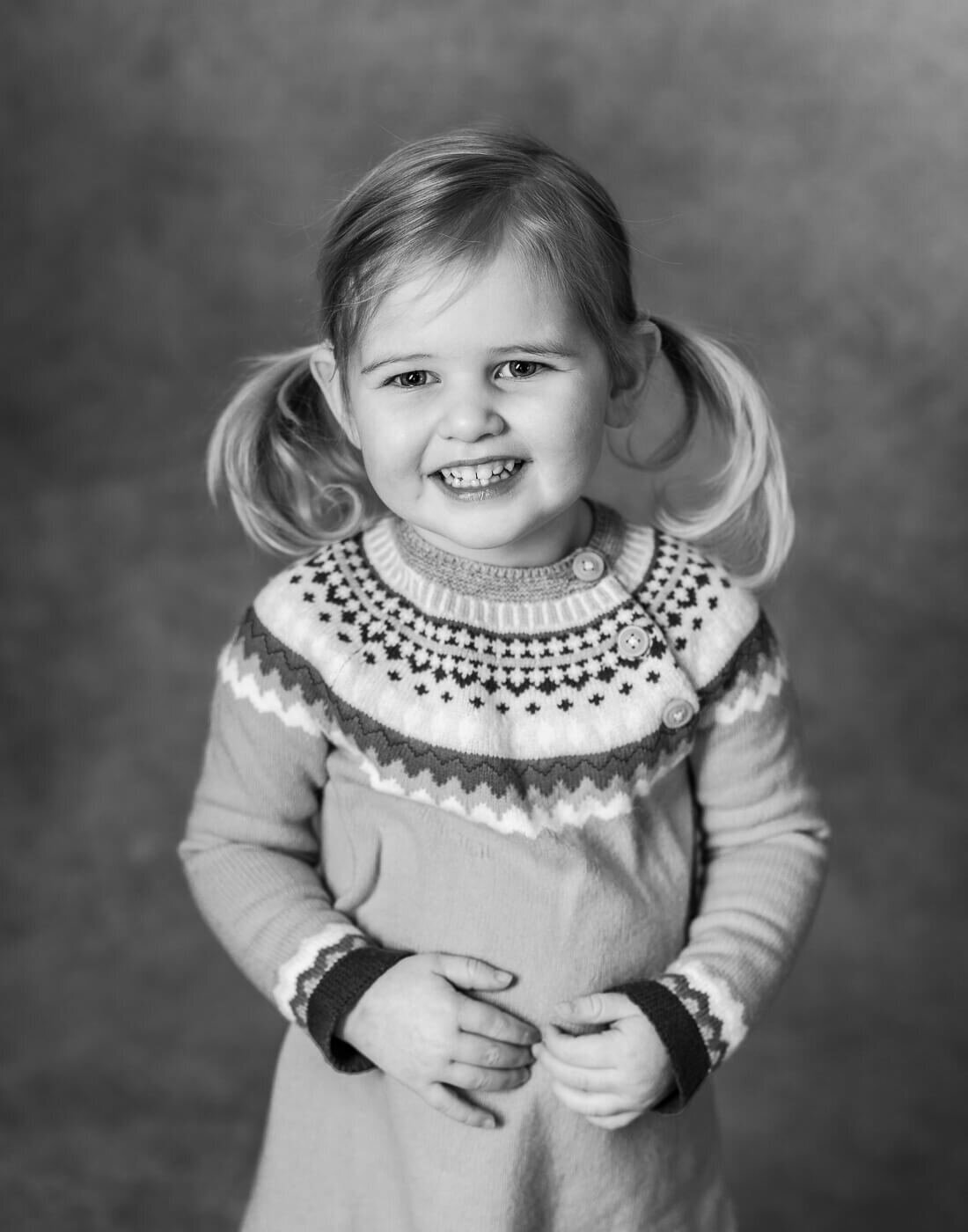 A child smiles with pigtails.