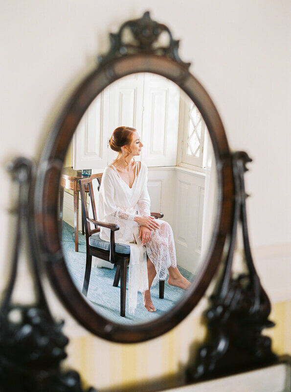 Bride getting ready and reflection in mirror intimate wedding at Bussaco Palace by Splendida Weddings