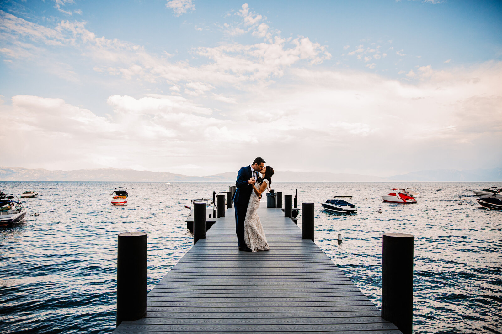 Couple eloping in Lake Tahoe at sunset, holding hands with mountain views in the background.