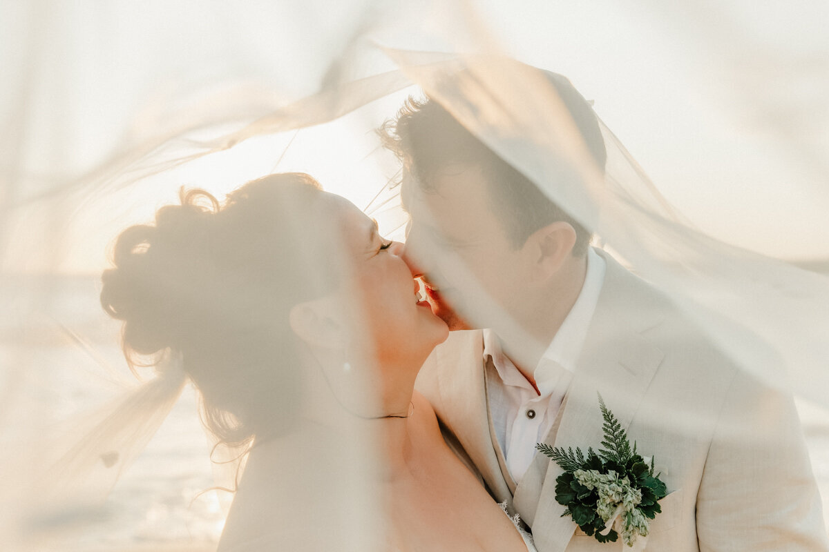 bride and groom kissing under the veil