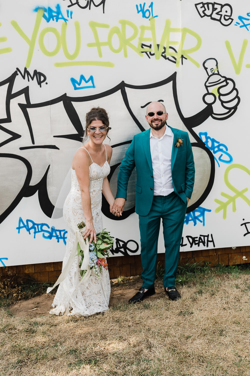 Wedding couple portrait in front of graffiti.