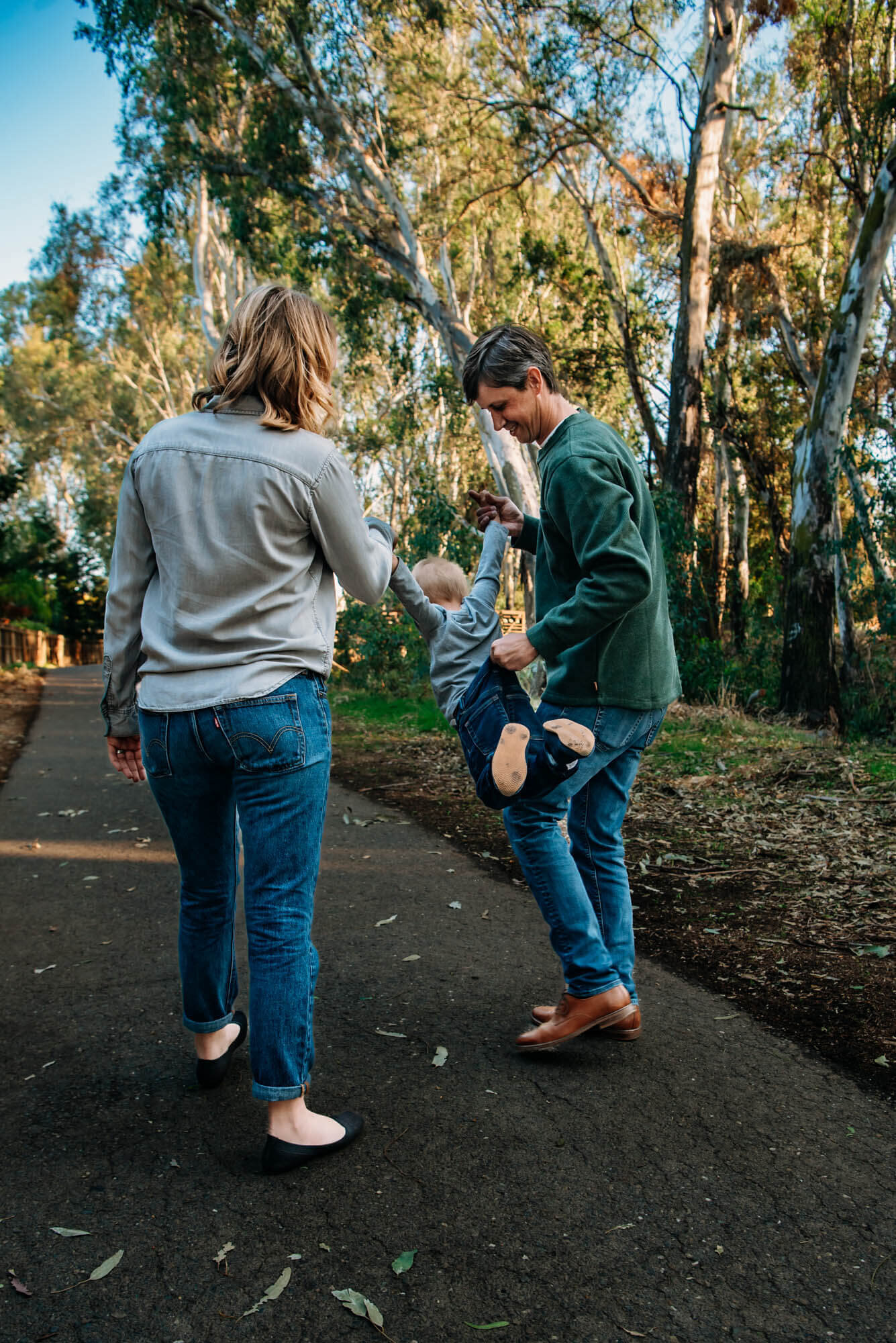 Mom and Dad with little boy during family photos at park