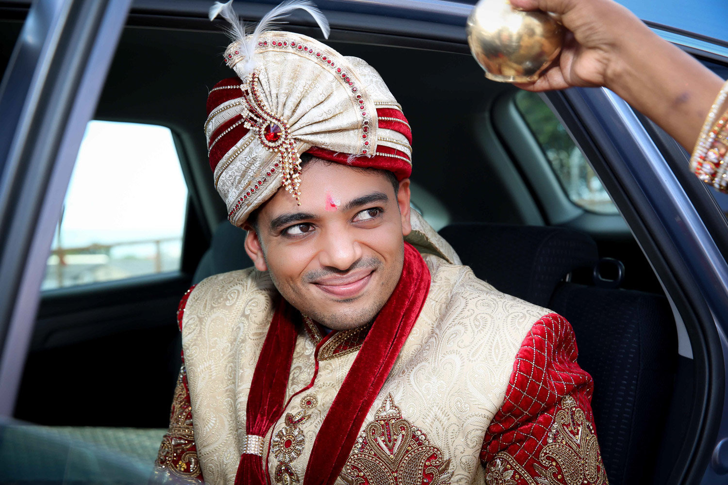 Indian groom receives blessing while coming out of car. Photo by Ross Photography, Trinidad, W.I..