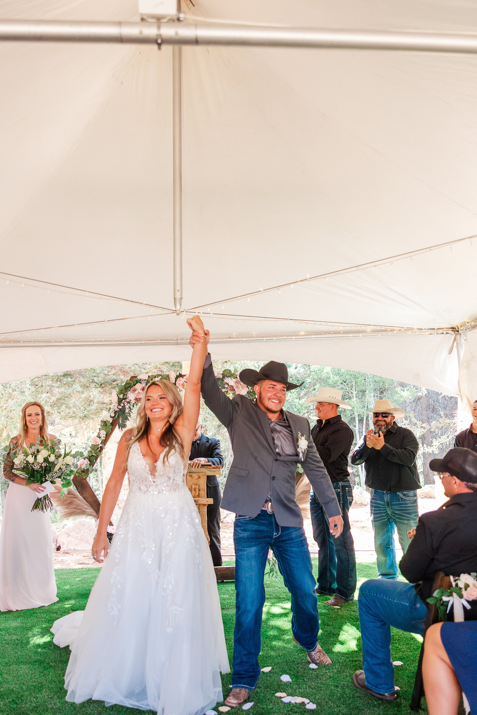 Newlyweds celebrating as they walk back down the aisle after saying ‘I do’ at their Arrowhead Lodge wedding, radiating pure joy.