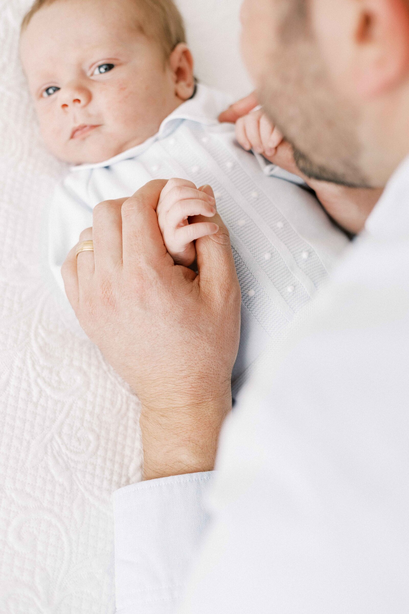 dad holding newborn baby's hand in peoria illinois newborn photos 