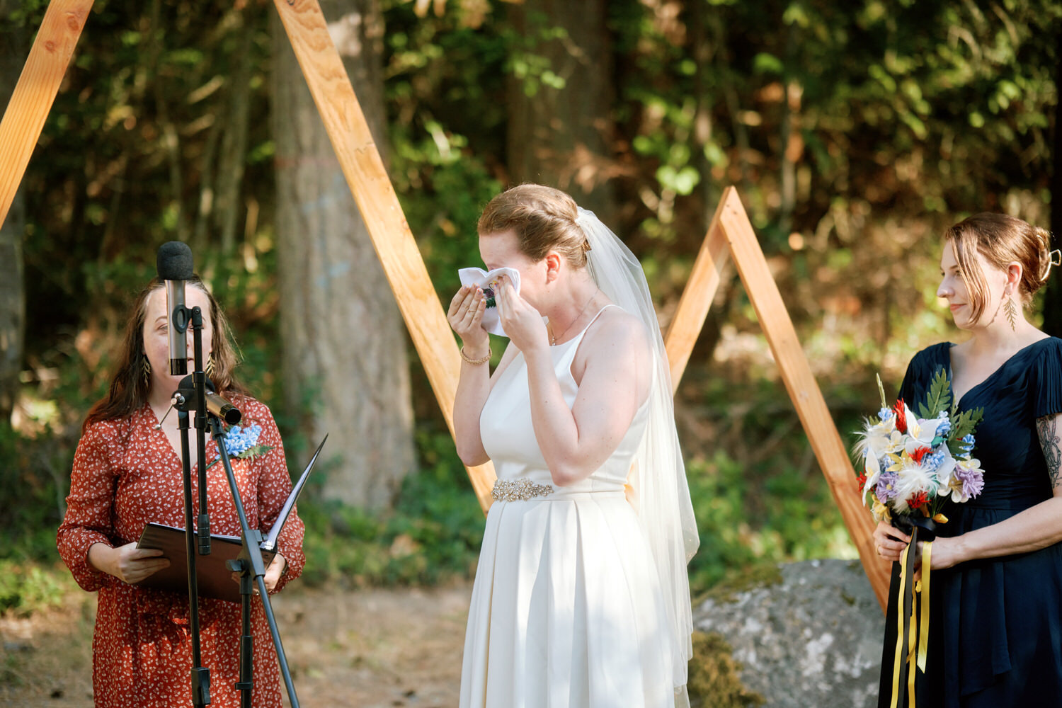 Bride wipes away a tear during the wedding ceremony.