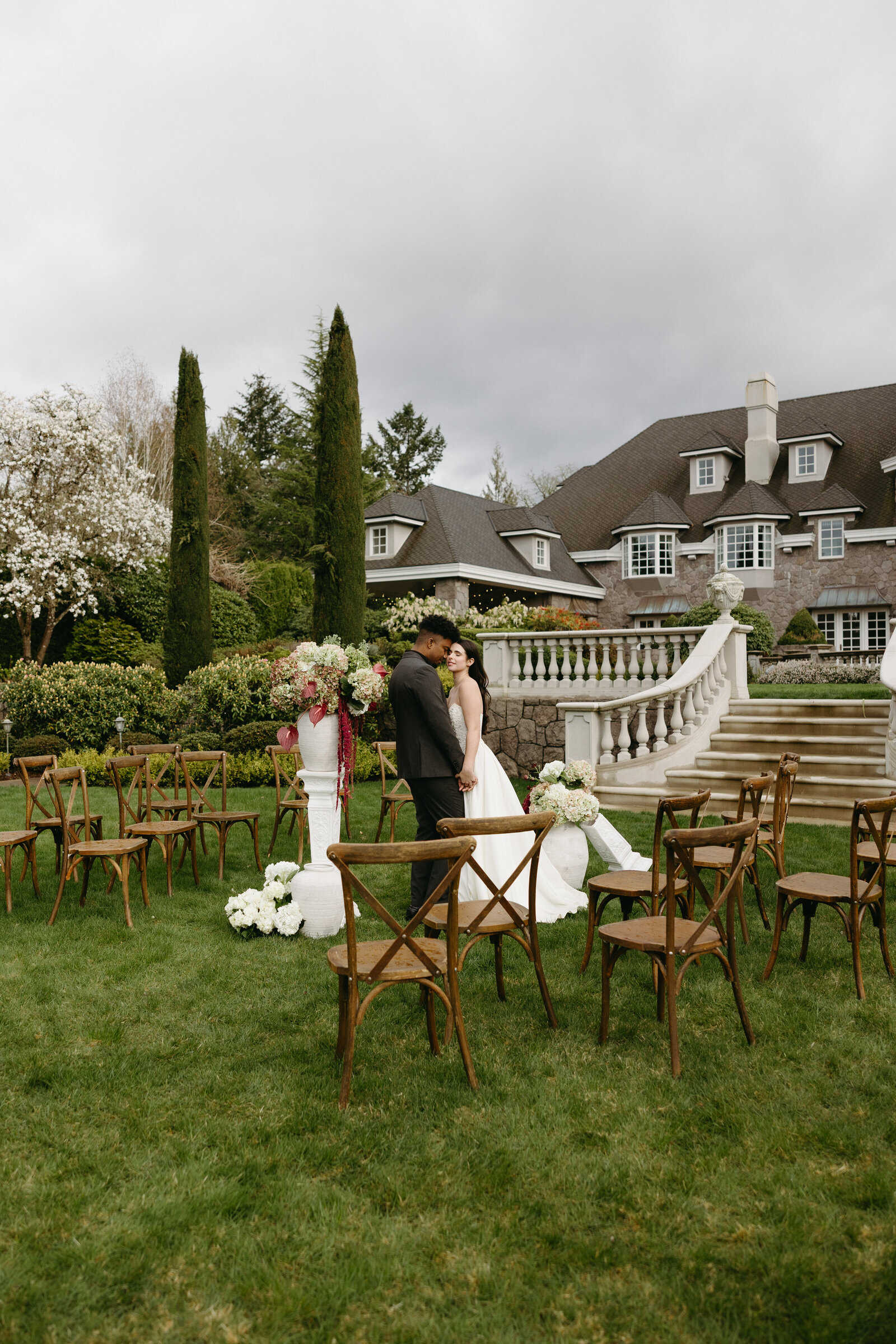 A couple poses next to their micro wedding set up at a beautiful chateau in Vancouver.