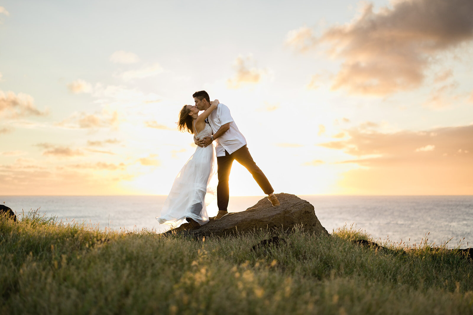 hawaii sunset couple kissing on rock