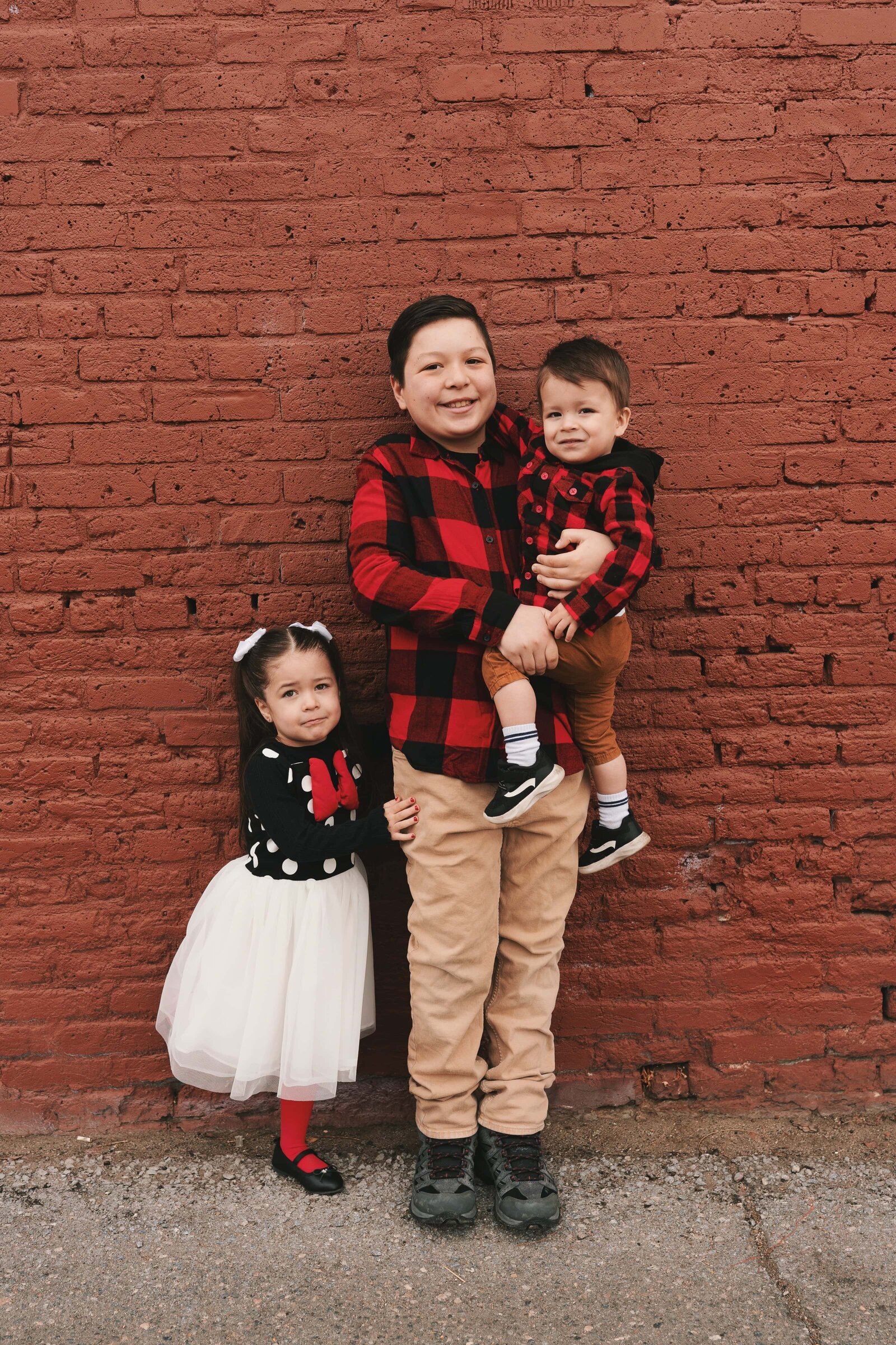brother-hugging-his-siblings-in-minnie-mouse-outfits-family-photographer-denver-3