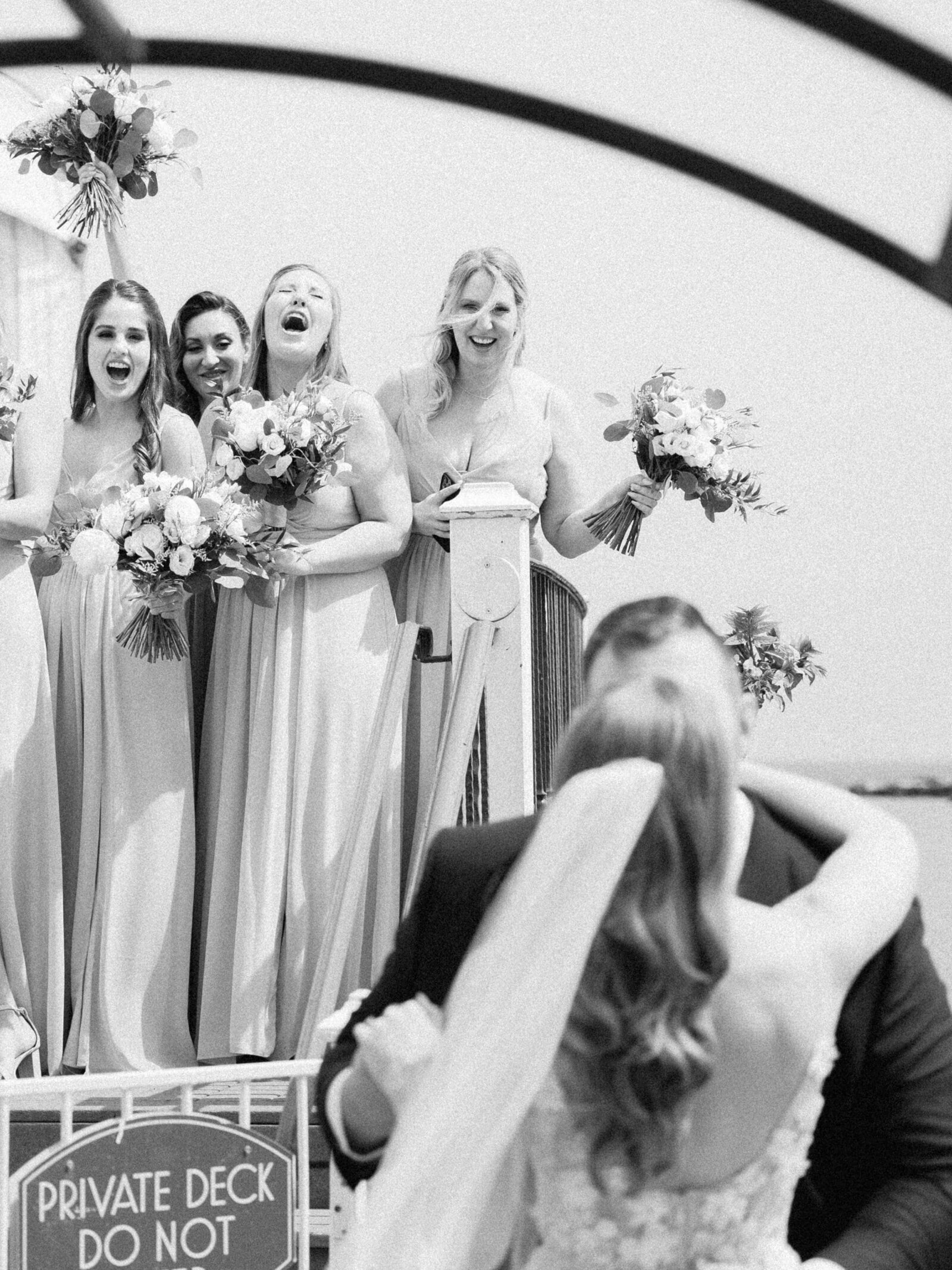 bridesmaids cheer on bride and groom kiss