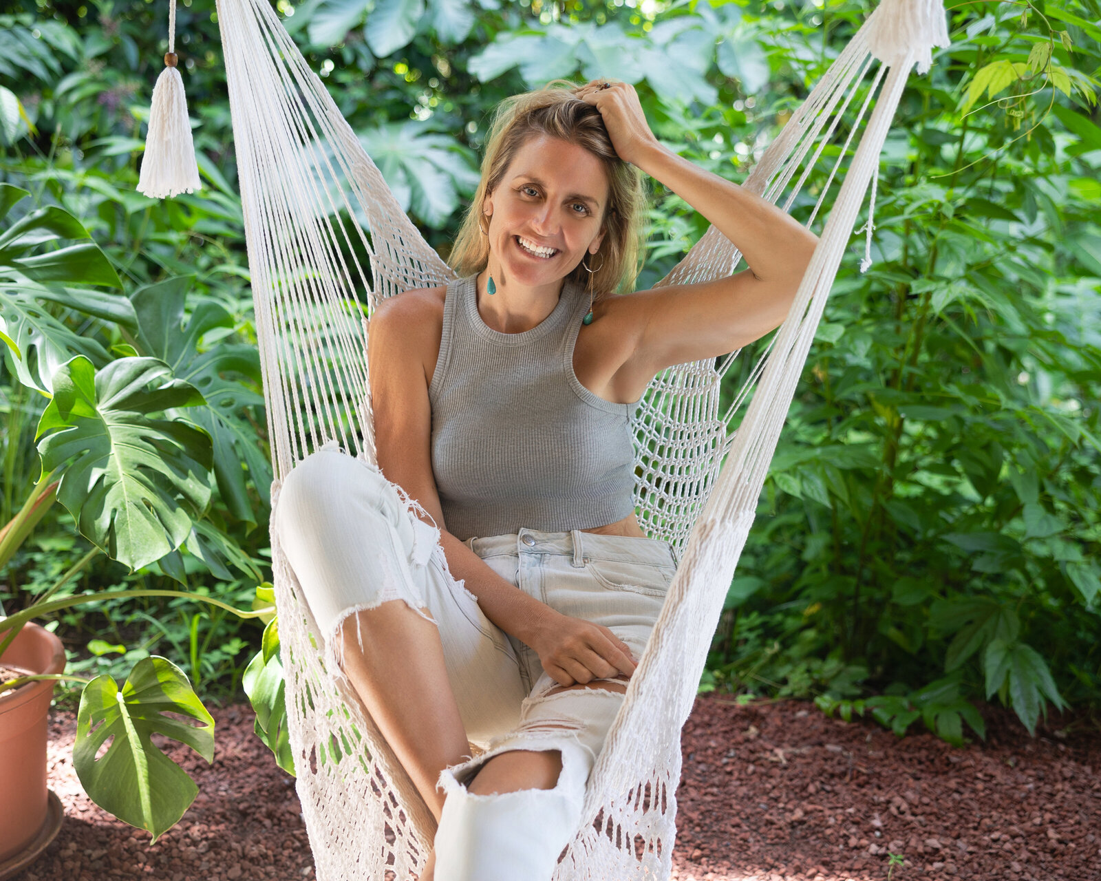 Jaime Hausler sits on a hammock seat and smiles at the camera