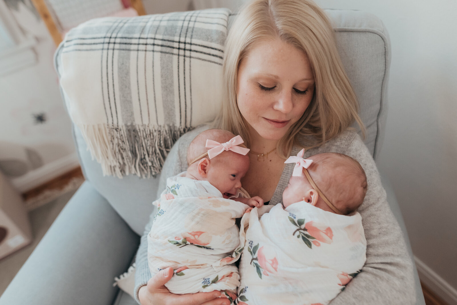 mom holding newborn twin girls