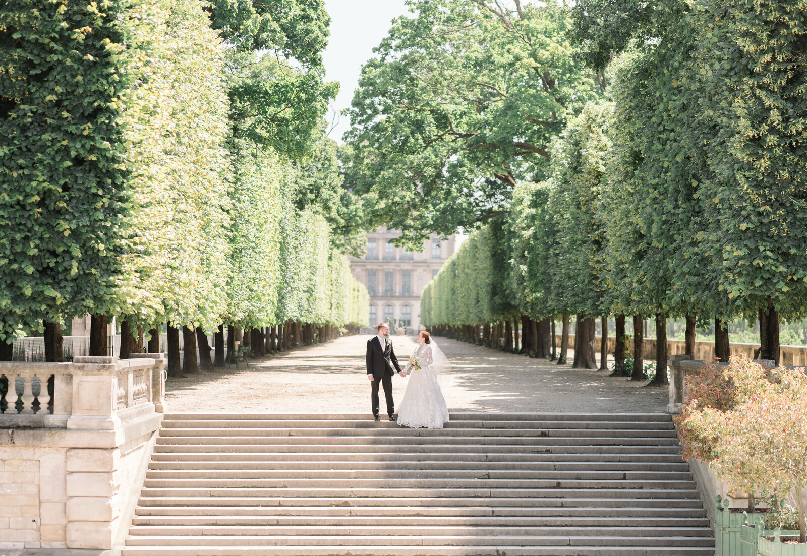 couple holding hands at the top of the stairs in Tuilieries Garden