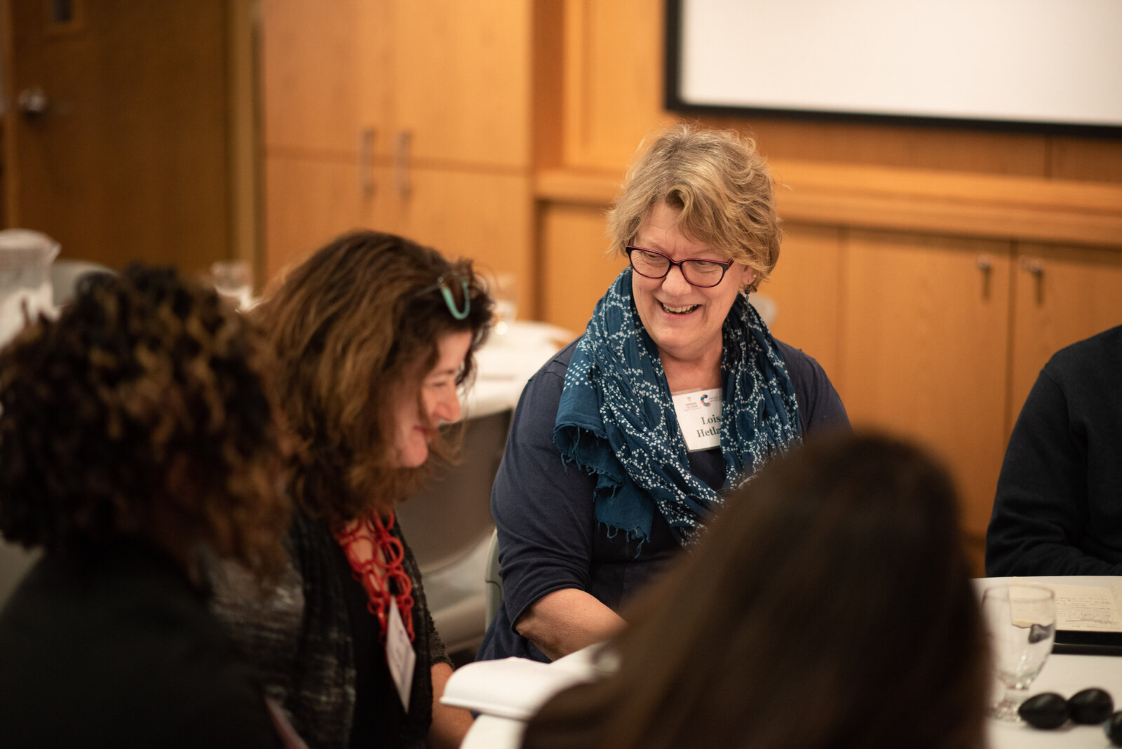 A person laughing at a table at the Harvard T.H. Chan School of Public Health