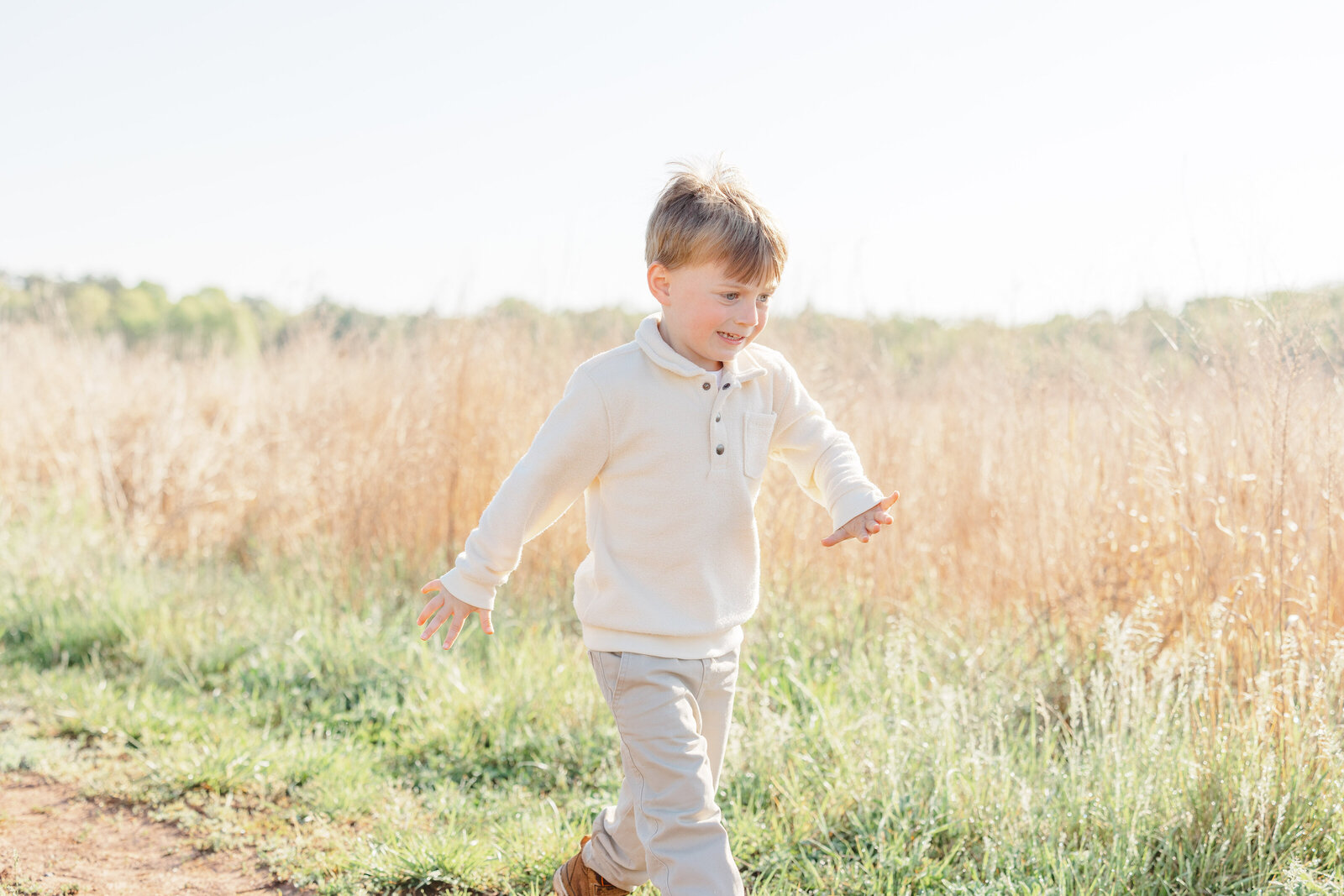 boy walking in a field during Warrenton, VA family session