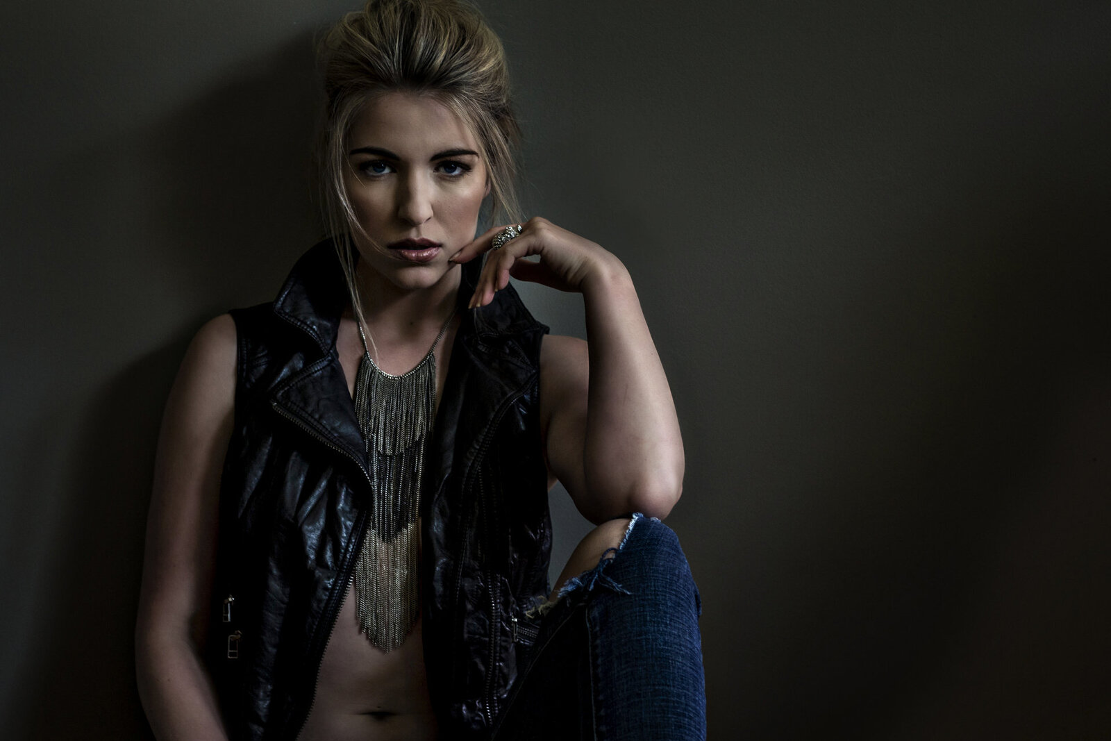Makeup for a model in a leather vest and jeans