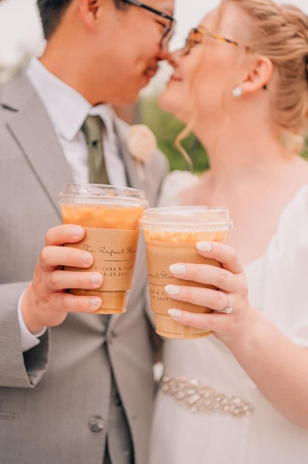 Bride and groom about to kiss while tossing their coffee