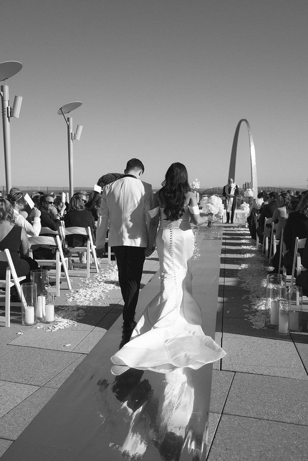 Candid wedding moment in St. Louis — joyful bride in off-shoulder gown and long veil laughing with family during outdoor ceremony, surrounded by loved ones in natural sunlight. Captured by Missouri-based traveling wedding photographer Jordan Grover specializing in authentic, emotional, documentary-style wedding photography.